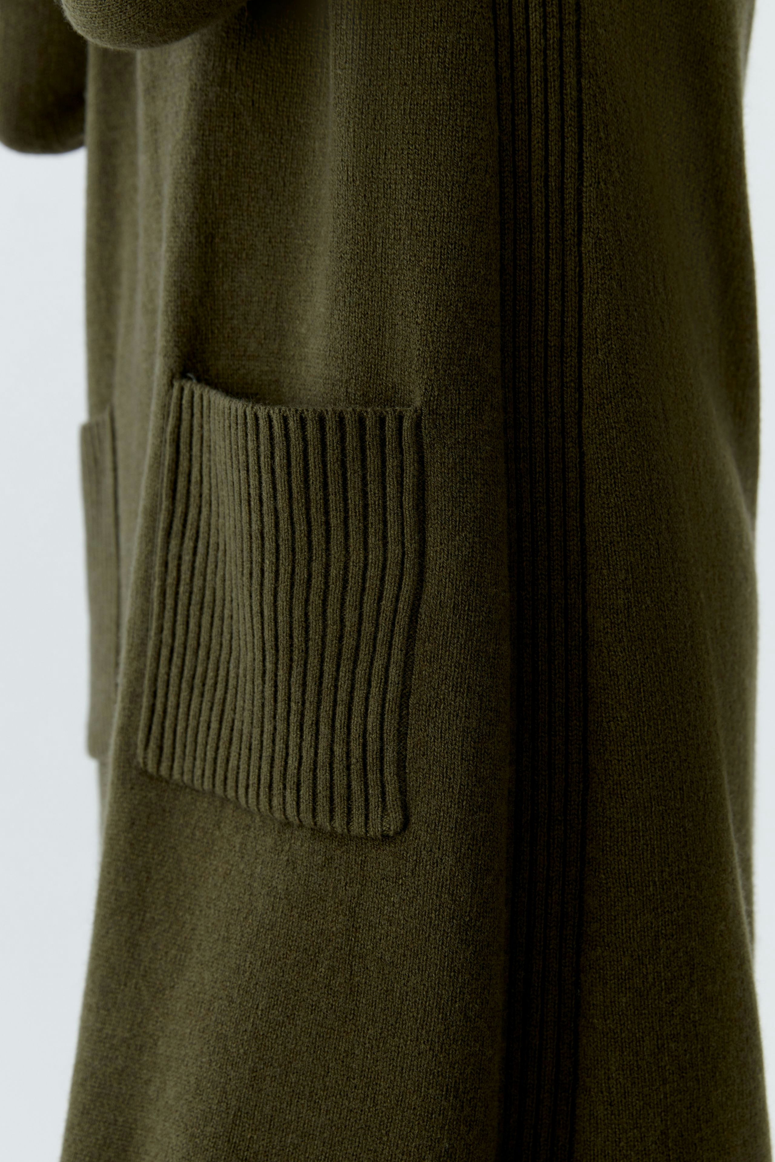 Casual women's knitted dress in olive green with ribbed pockets and a relaxed fit.
