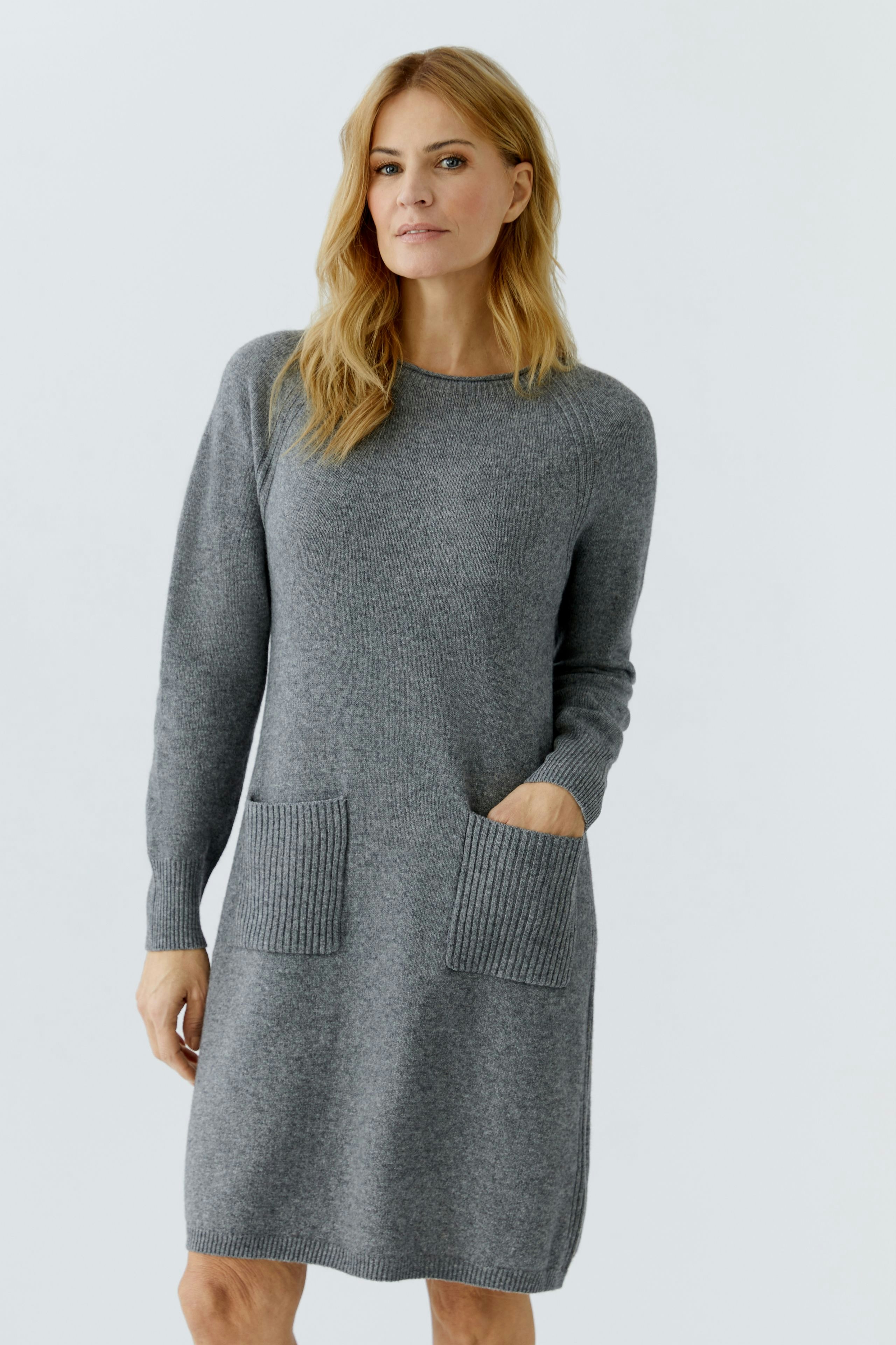 Casual women's knitted dress: A woman in a gray knitted dress with two front pockets.