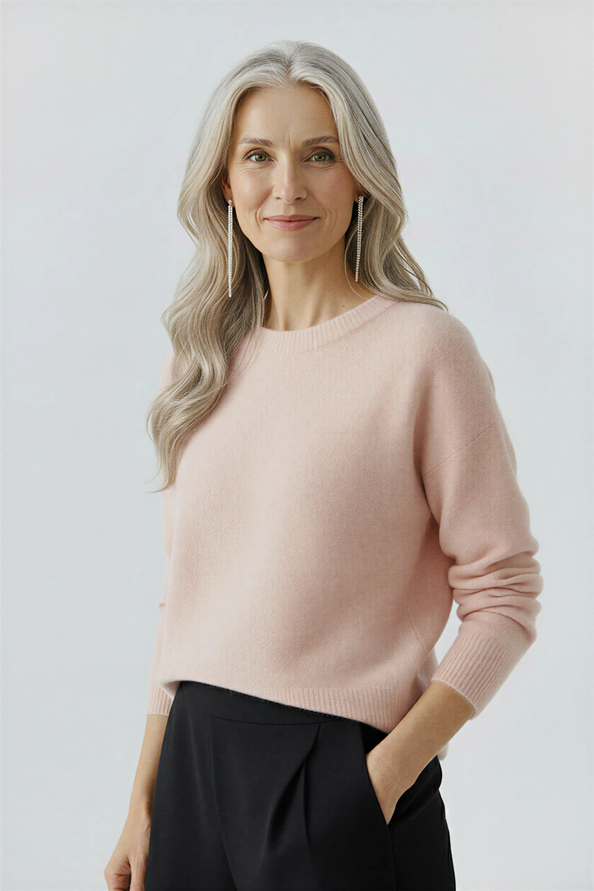 Casual women's pullover: A woman in a soft pink pullover with a relaxed fit and simple design.