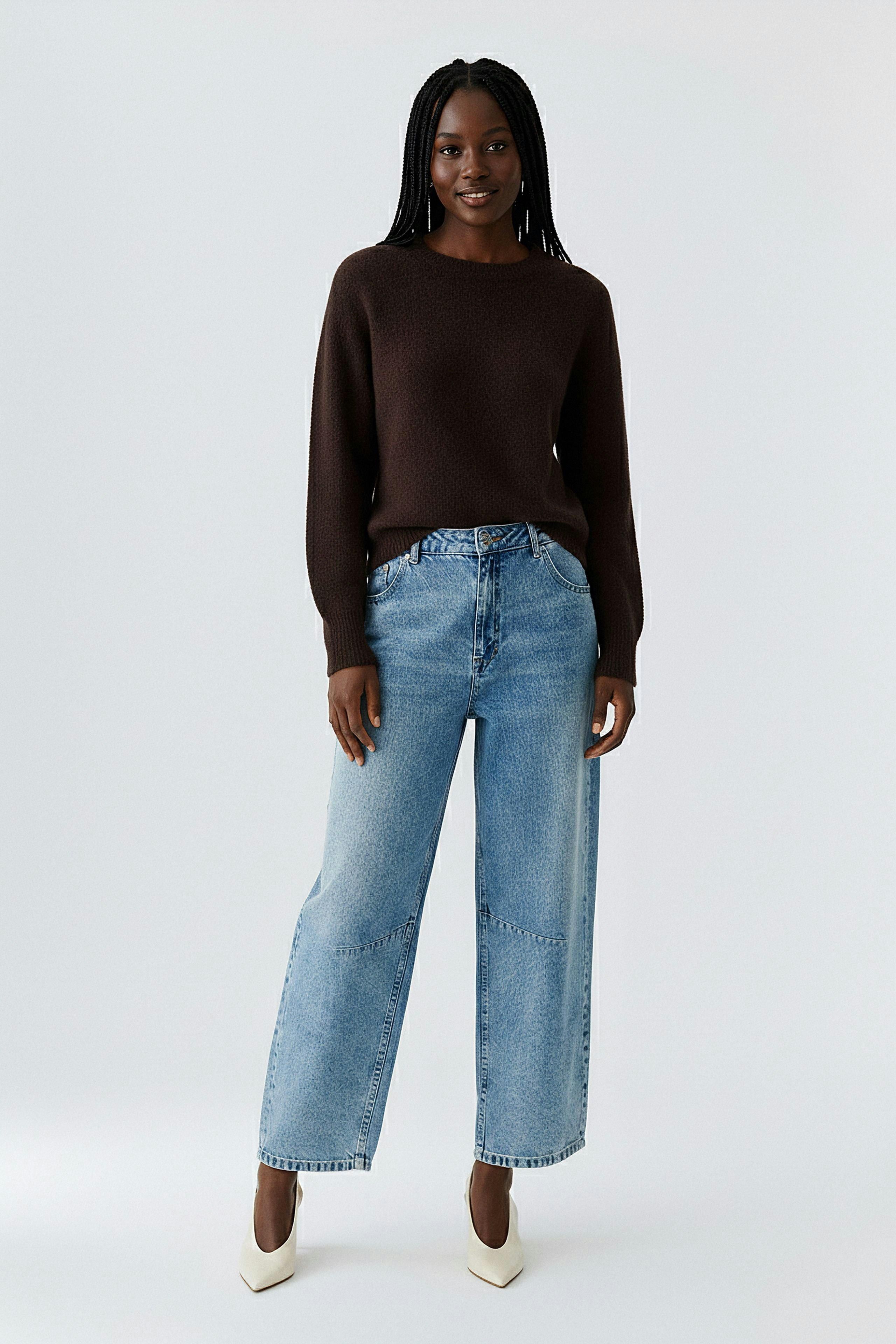 Casual women's pullover: A woman in a brown pullover paired with wide-leg jeans, exuding a relaxed vibe.