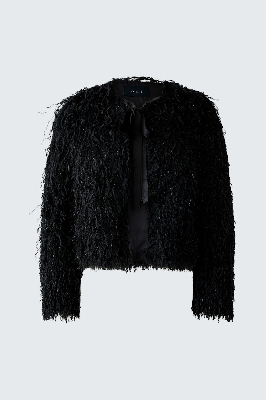 Fuzzy black jacket: A woman in a stylish, textured jacket with a tie detail, exuding a casual vibe.