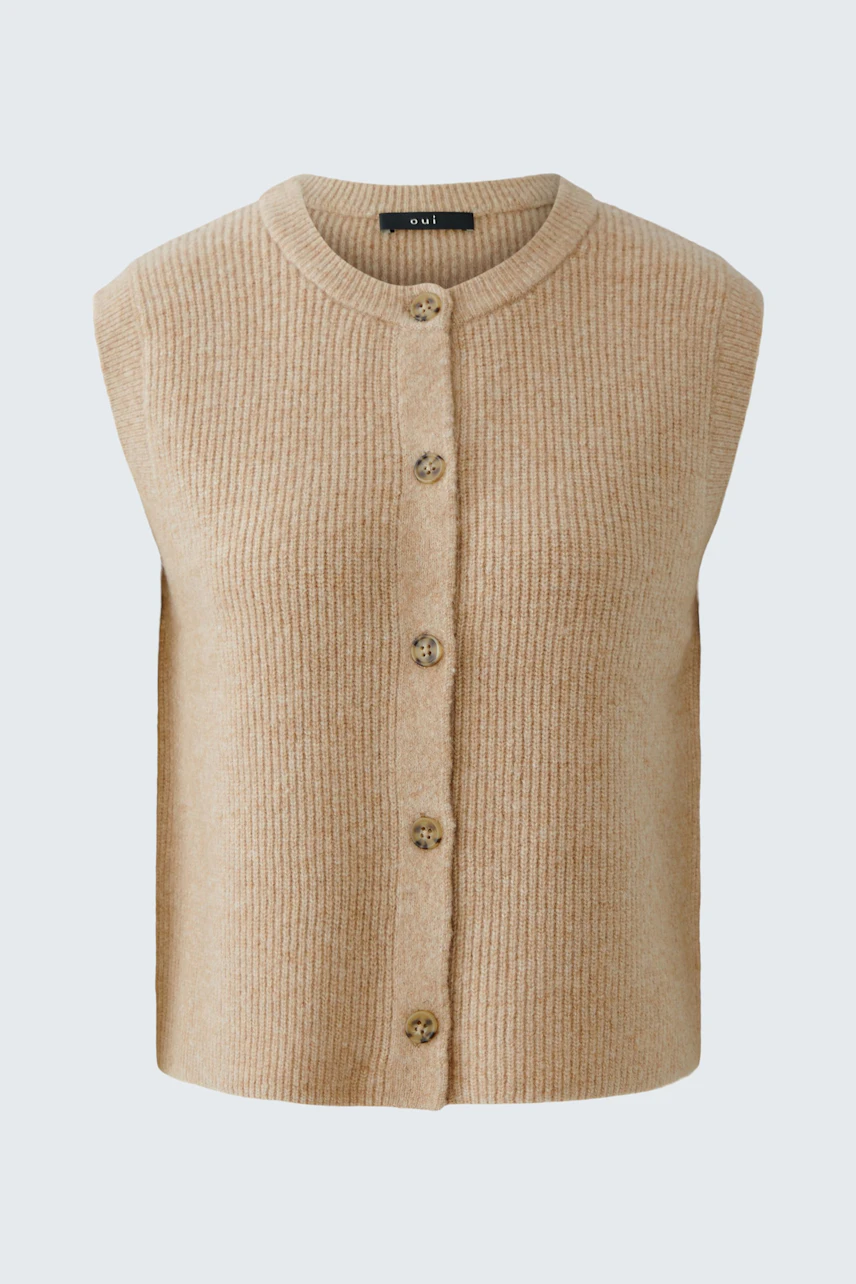Casual women's vest: A woman in a beige sleeveless vest with buttons, perfect for layering.