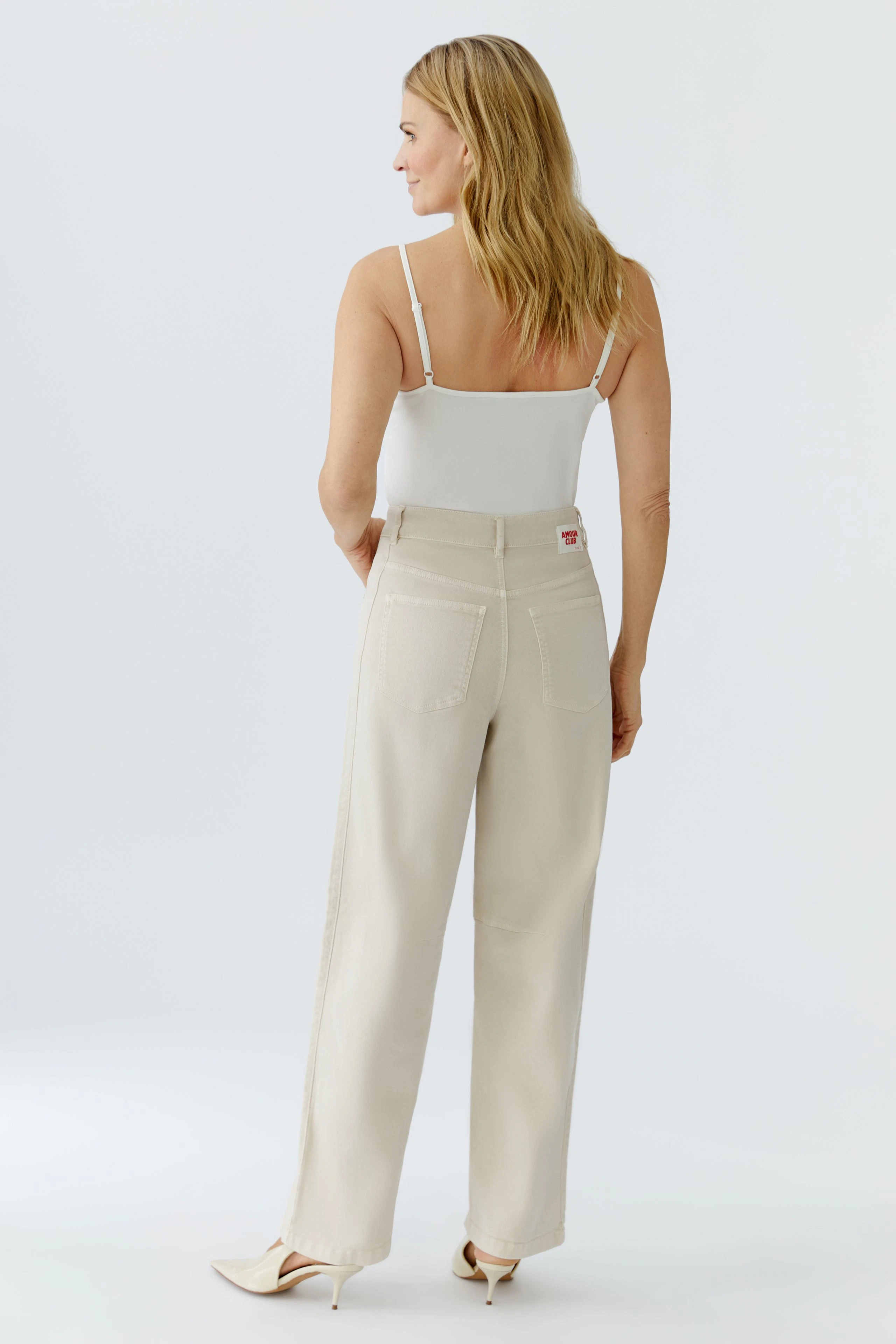 Bequeme Damen-Jeans Barrel: Frau mit blonden Haaren trägt helle, lässige Jeans mit weitem Schnitt.