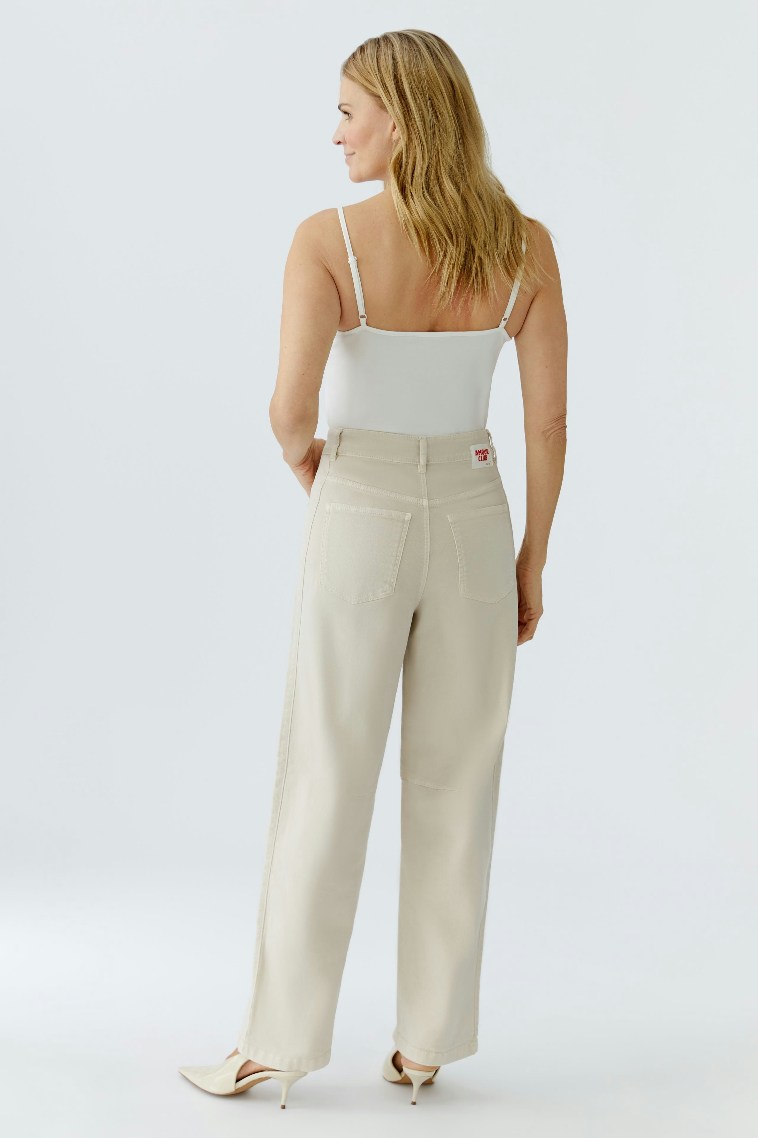 Casual women's jeans: A woman in light beige barrel jeans with a relaxed fit, showcasing a simple design.