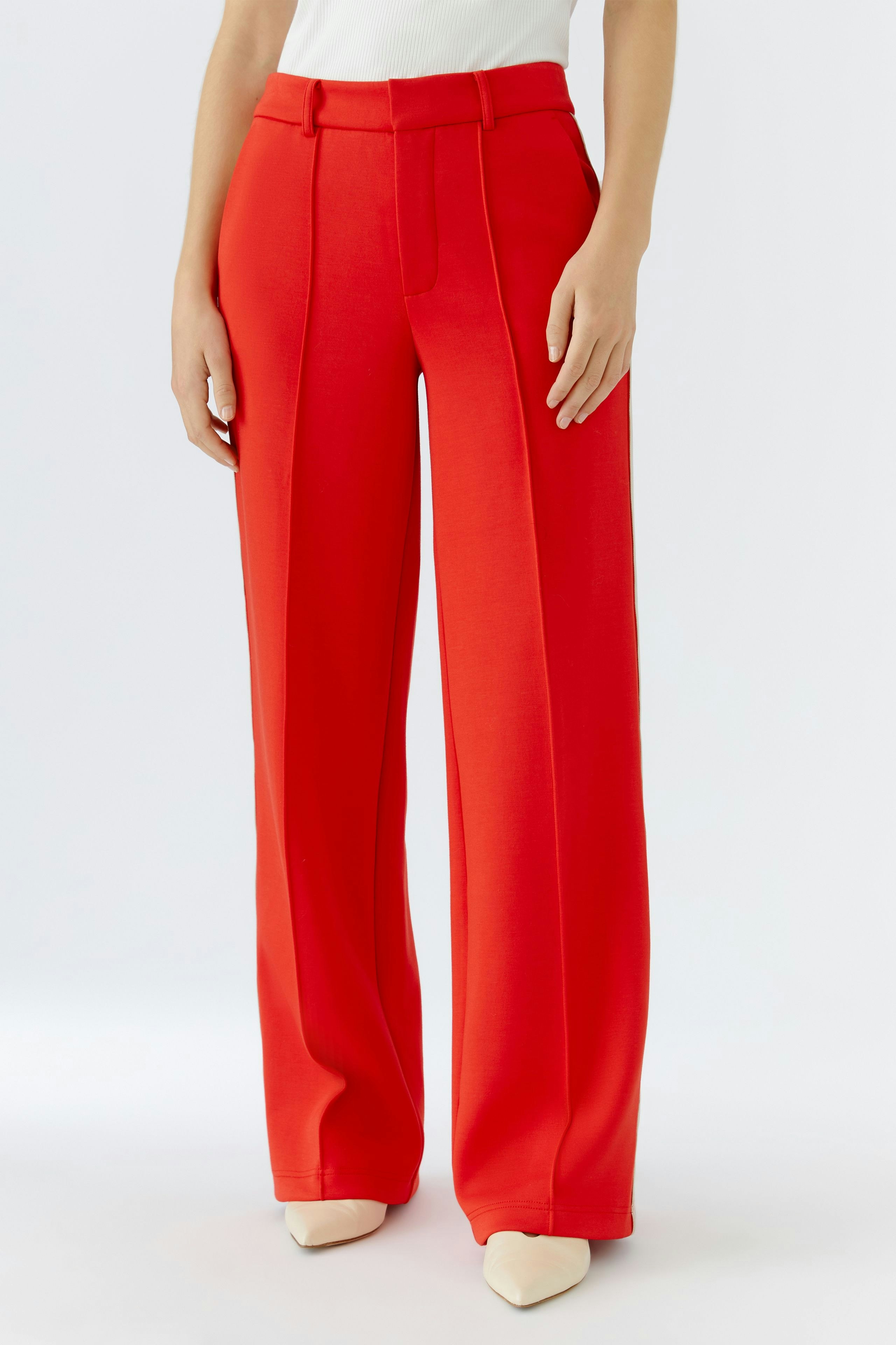 Moderne Damen-Hose: Frau in roter, weit geschnittener Hose mit hohen Taschen und schmalem Bund.