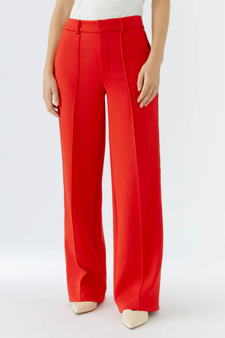 Moderne Damen-Hose: Frau in roter, weit geschnittener Hose mit hohen Taschen und schmalem Bund.