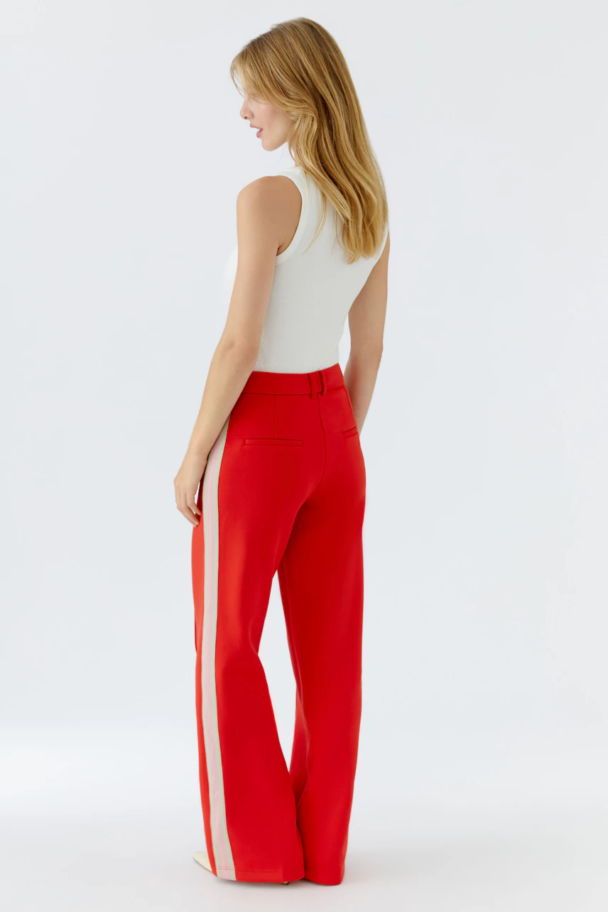Bequeme Damen-Hose: Frau in roter Hose mit seitlichen Streifen, lässig und modern.