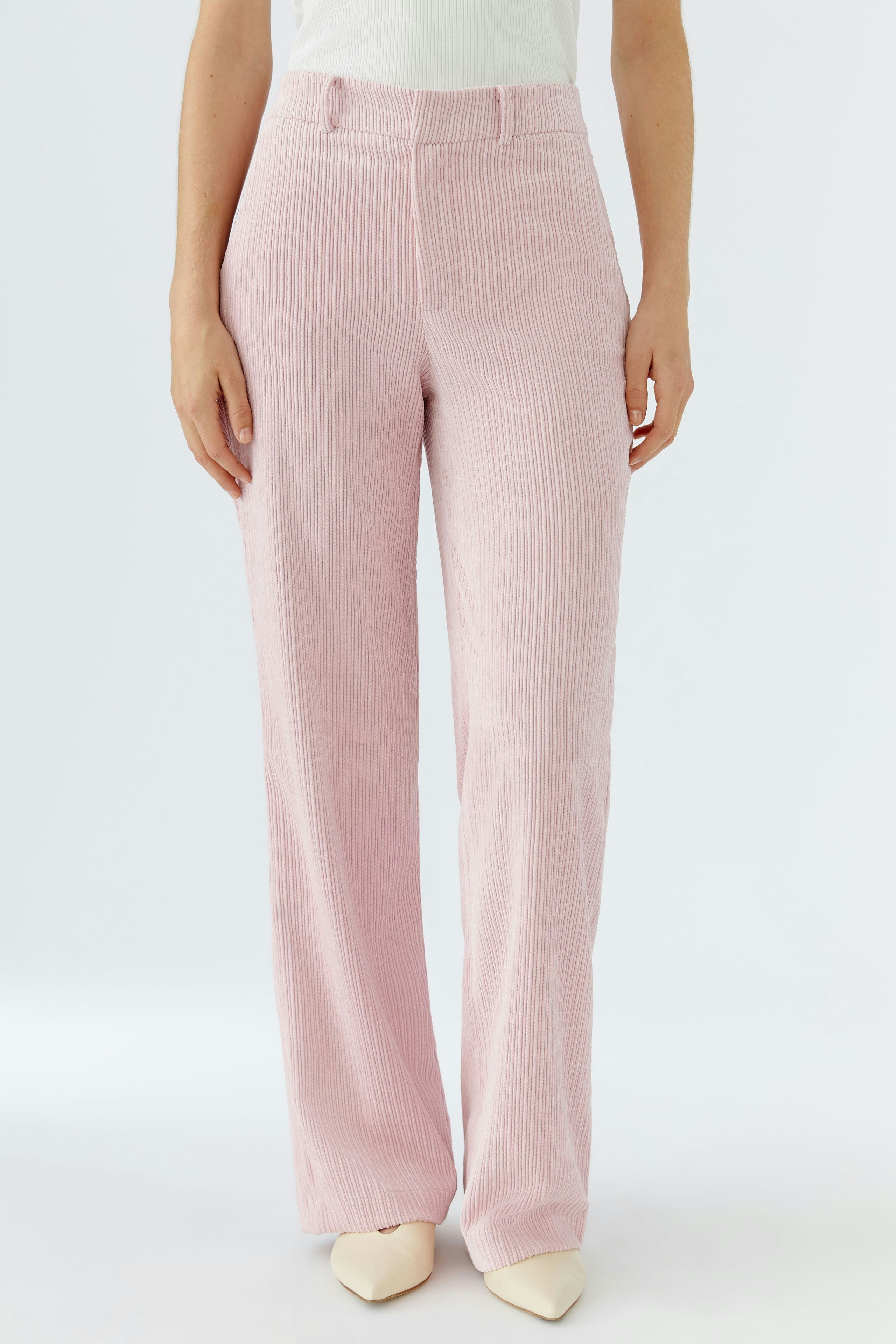 Moderne Cordhose: Frau in rosa Cordhose mit geradem Schnitt und lässigem Look.