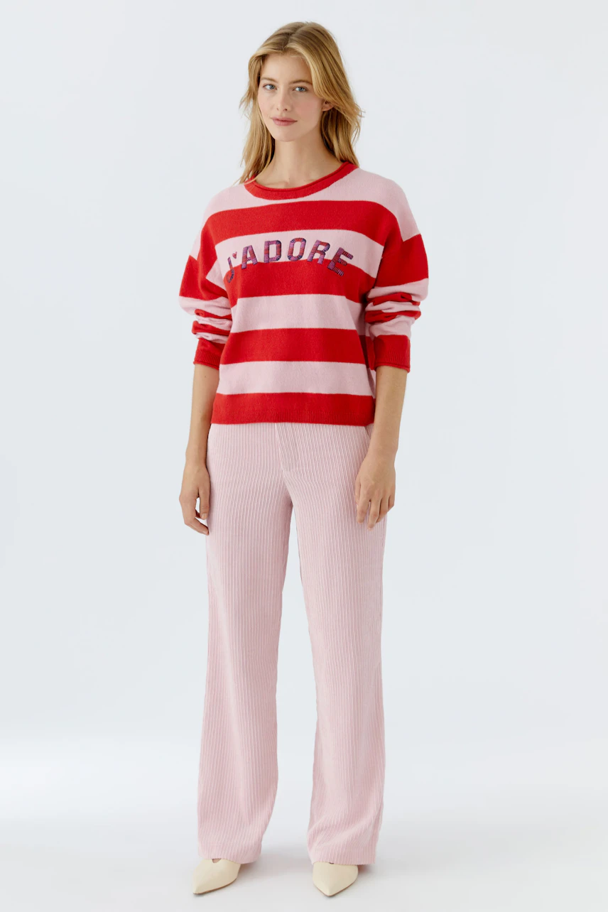 Casual cord pants: Woman in pink corduroy pants paired with a striped pullover, exuding a relaxed vibe.