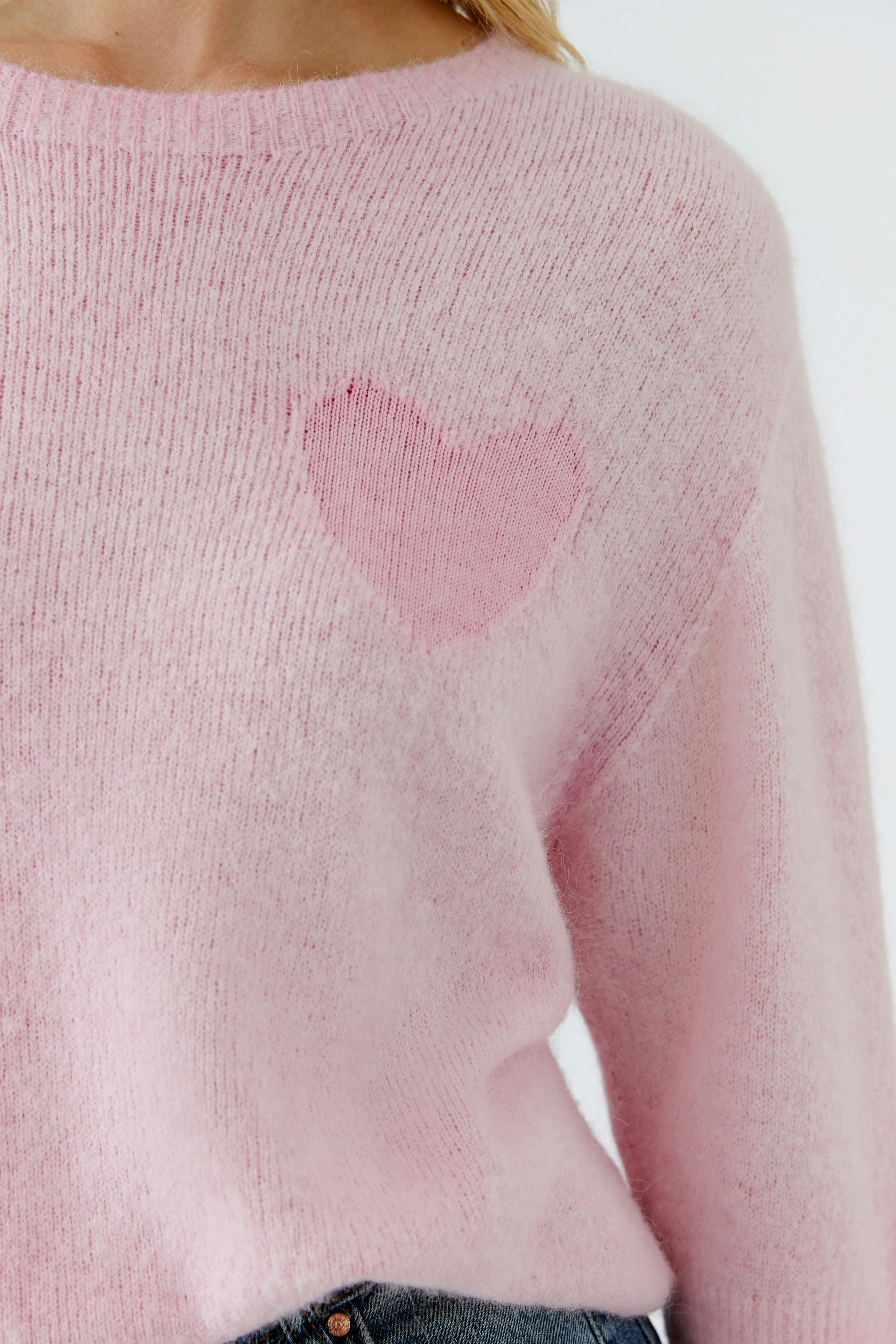 Damen-Pullover in zartem Rosa mit Herz-Applikation auf der Brust, lässig und bequem.