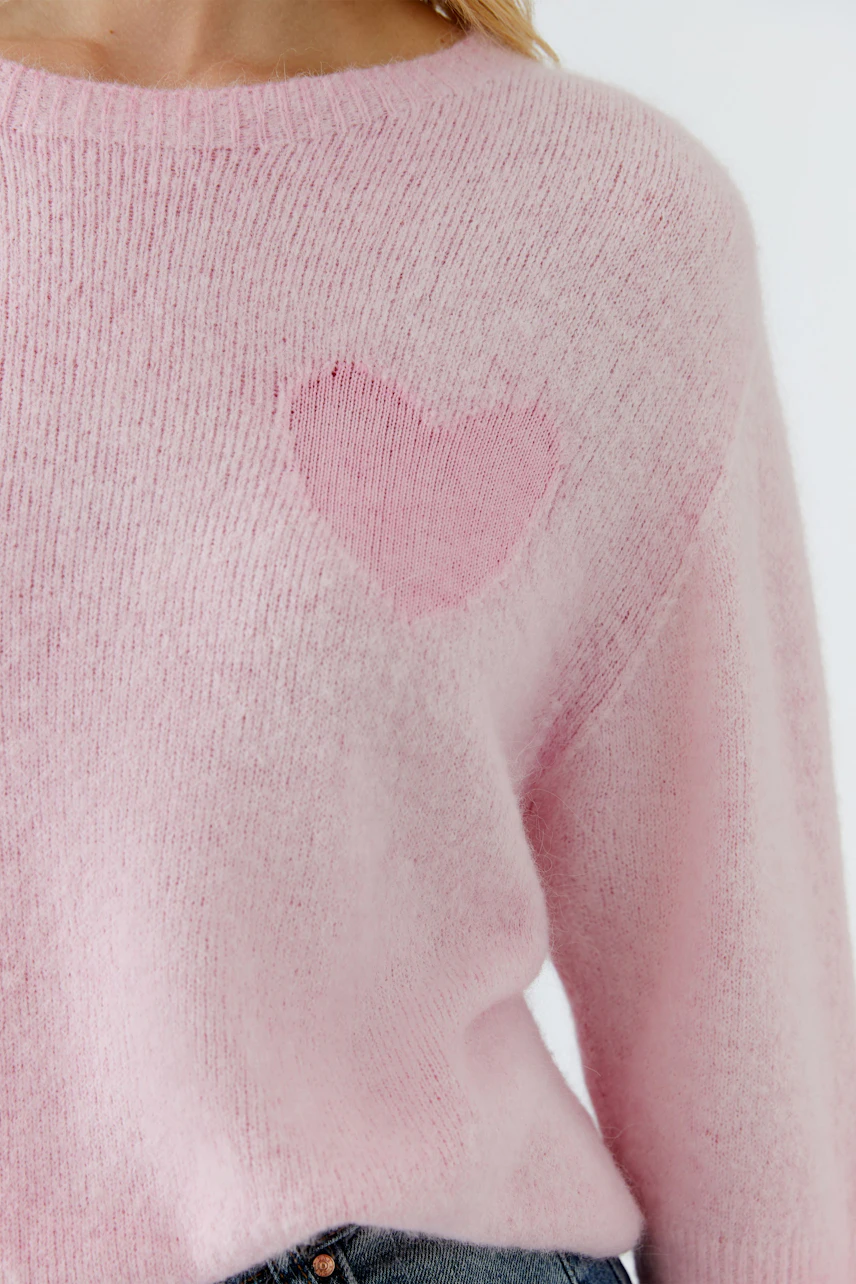 Damen-Pullover in zartem Rosa mit Herz-Applikation auf der Brust, lässig und bequem.