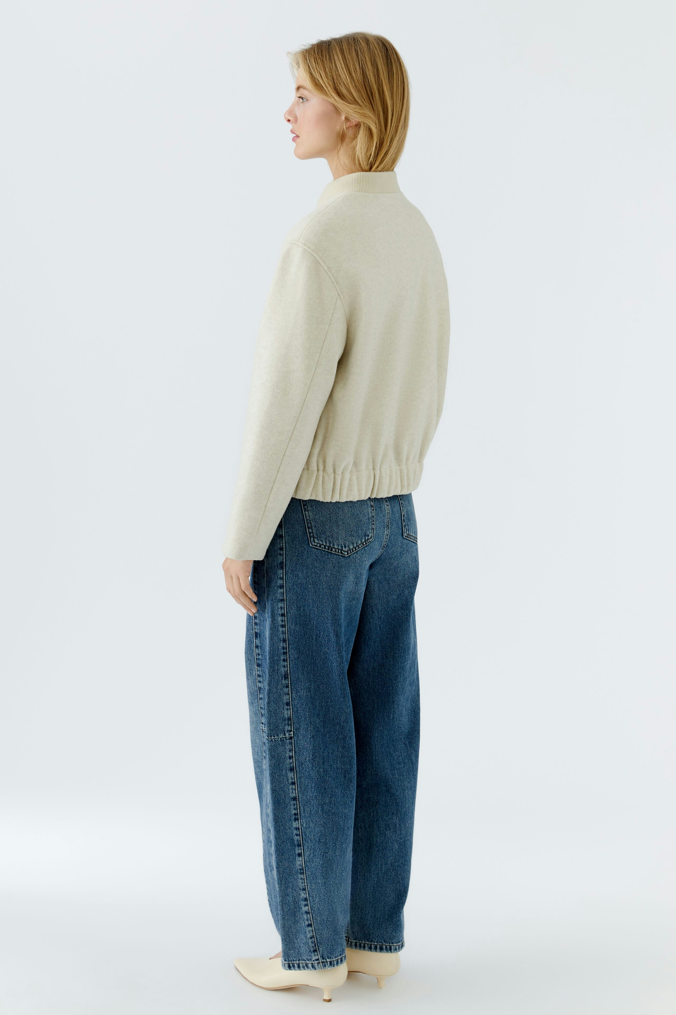 Casual women's blouson: A woman in a light beige blouson with a relaxed fit and elastic hem.