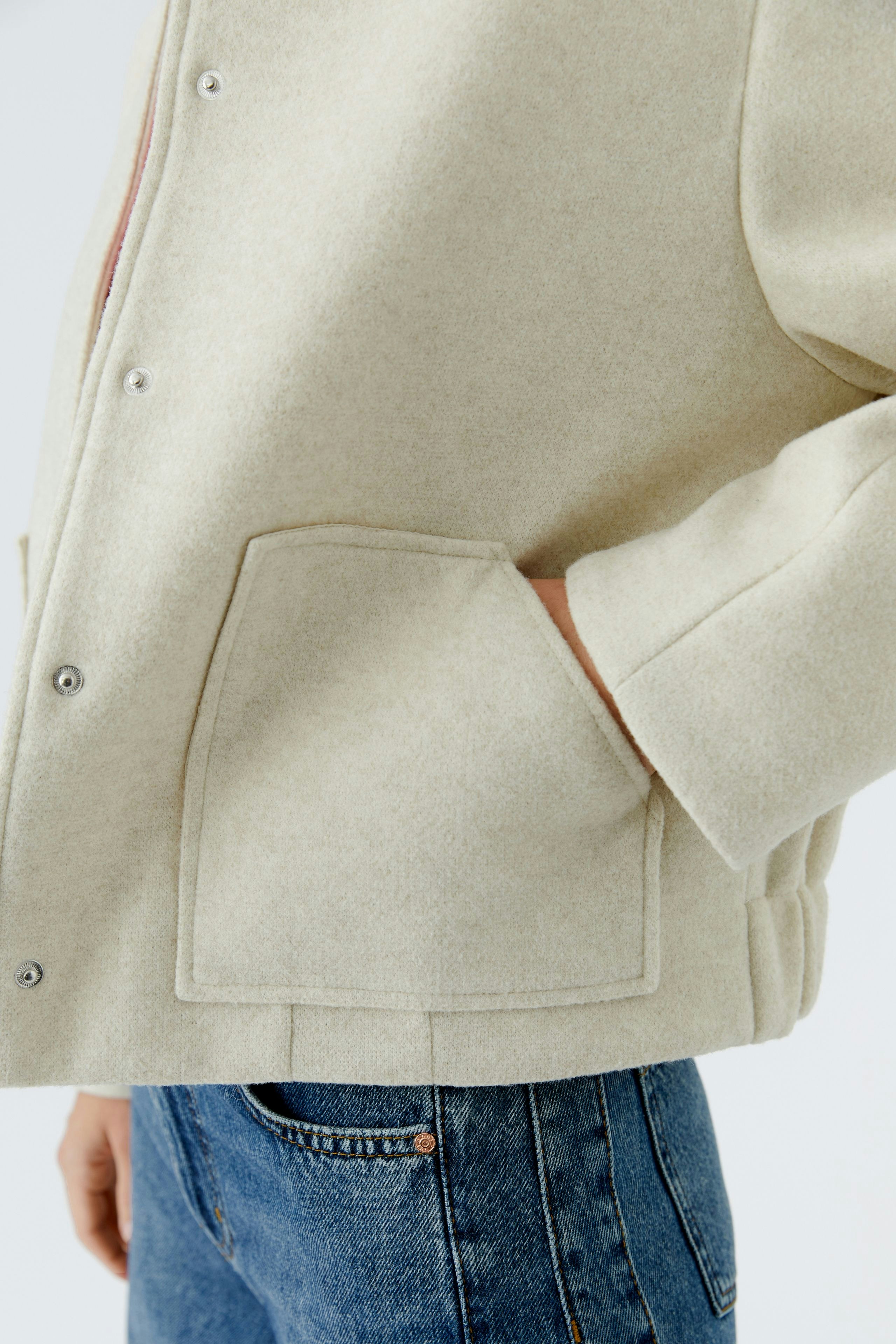 Casual women's blouson: A woman in a light beige jacket with pockets, paired with denim jeans.