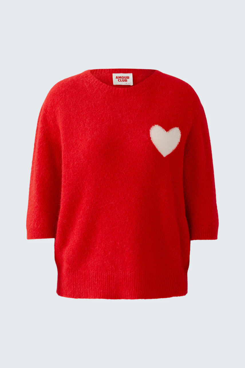 Cozy red pullover with a white heart detail, perfect for casual wear.