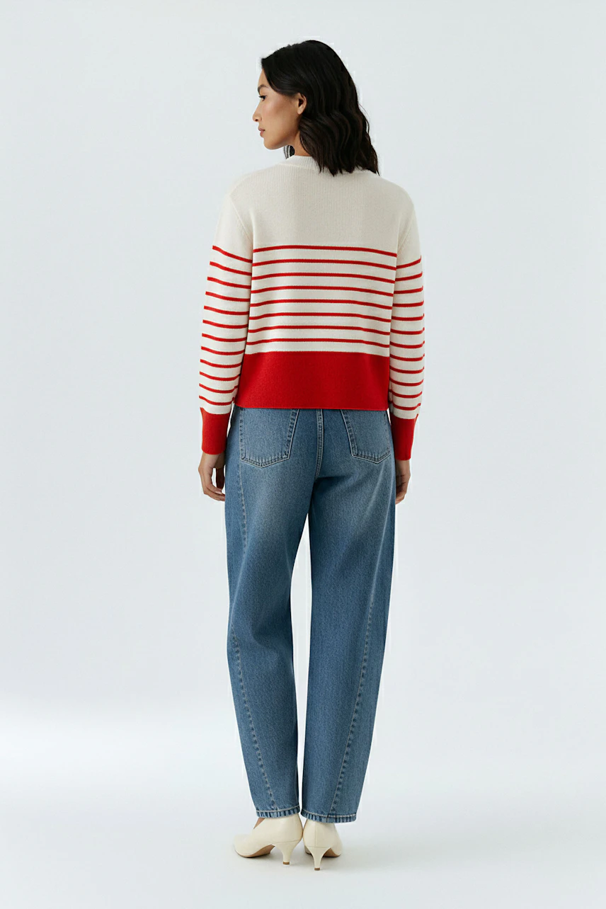 Casual women's pullover: A woman in a striped pullover with red and white stripes, paired with blue jeans.