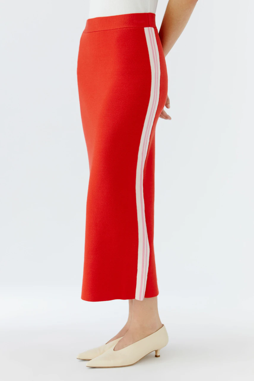 Modern women's knit skirt: A woman in a red skirt with white stripes, showcasing a casual style.