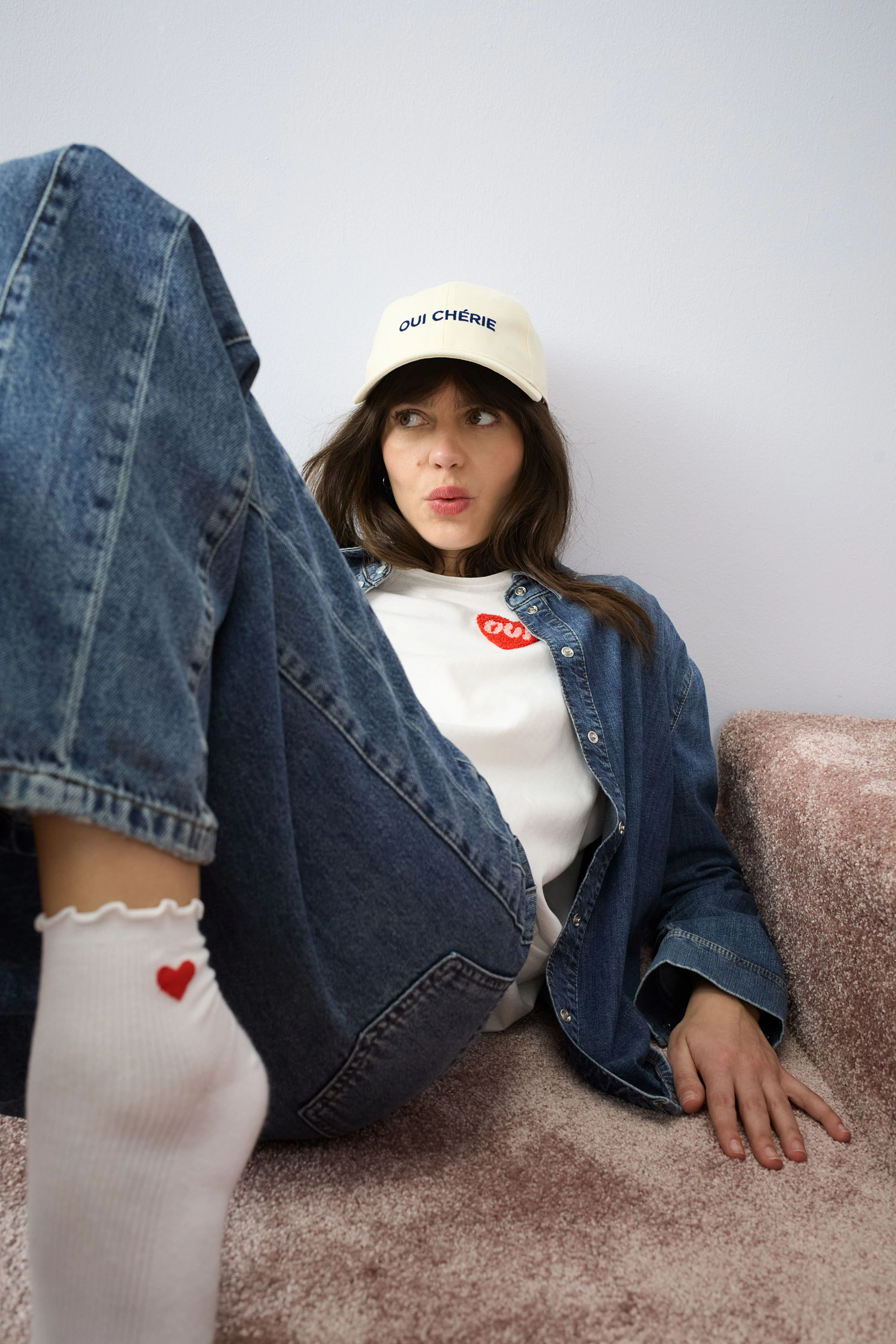 Casual women's T-shirt: Young woman in a white T-shirt with a red logo, paired with denim.