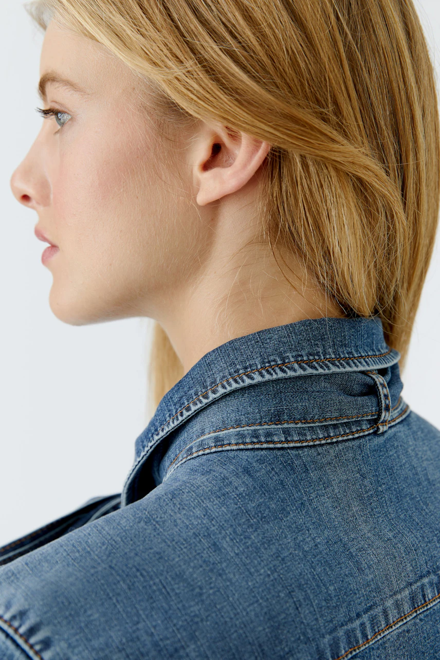 Damen-Jeanshemd: Frau mit blonden Haaren trägt ein lässiges Jeanshemd mit klassischem Kragen.