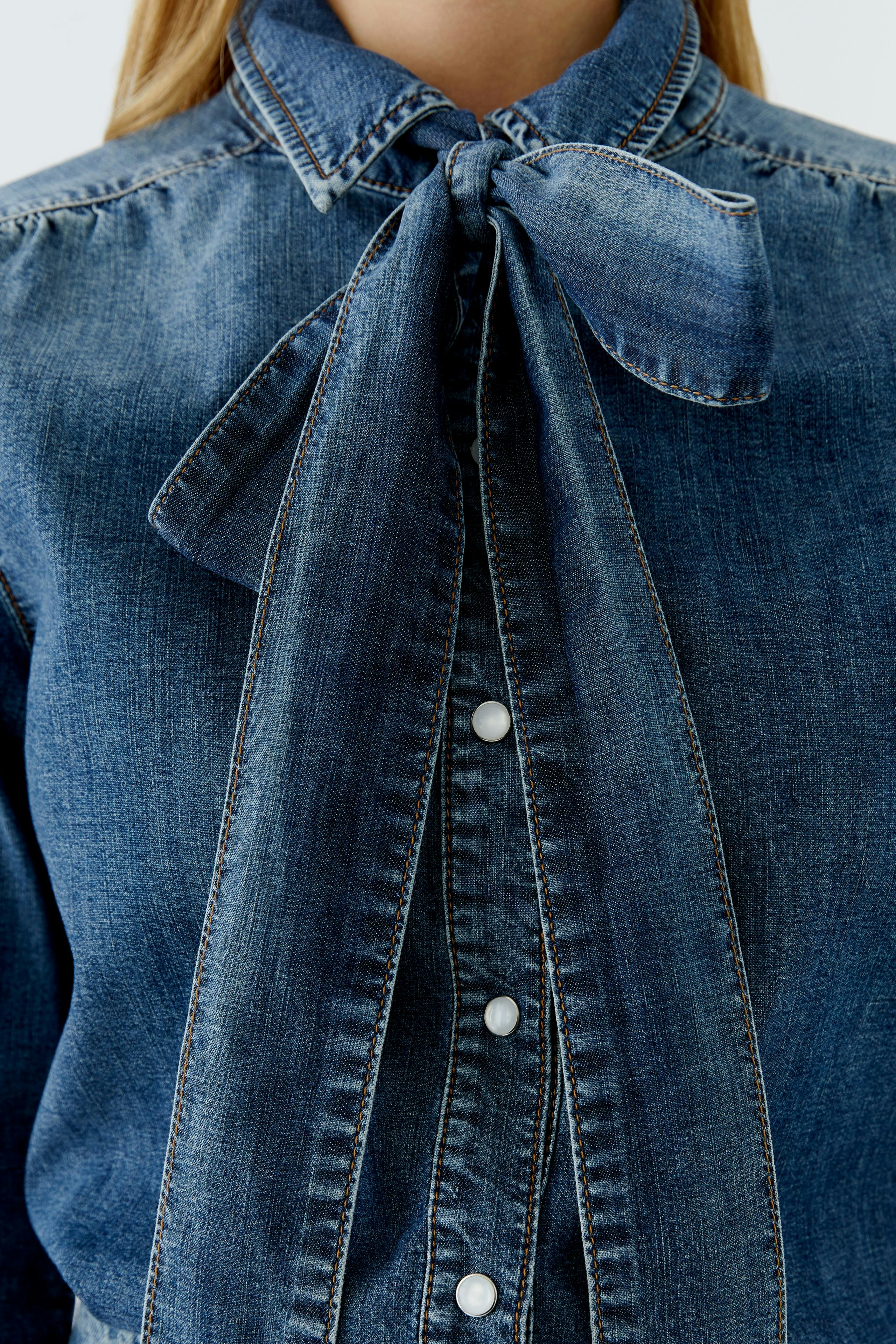 Casual women's denim shirt with a bow tie collar and button-down front.