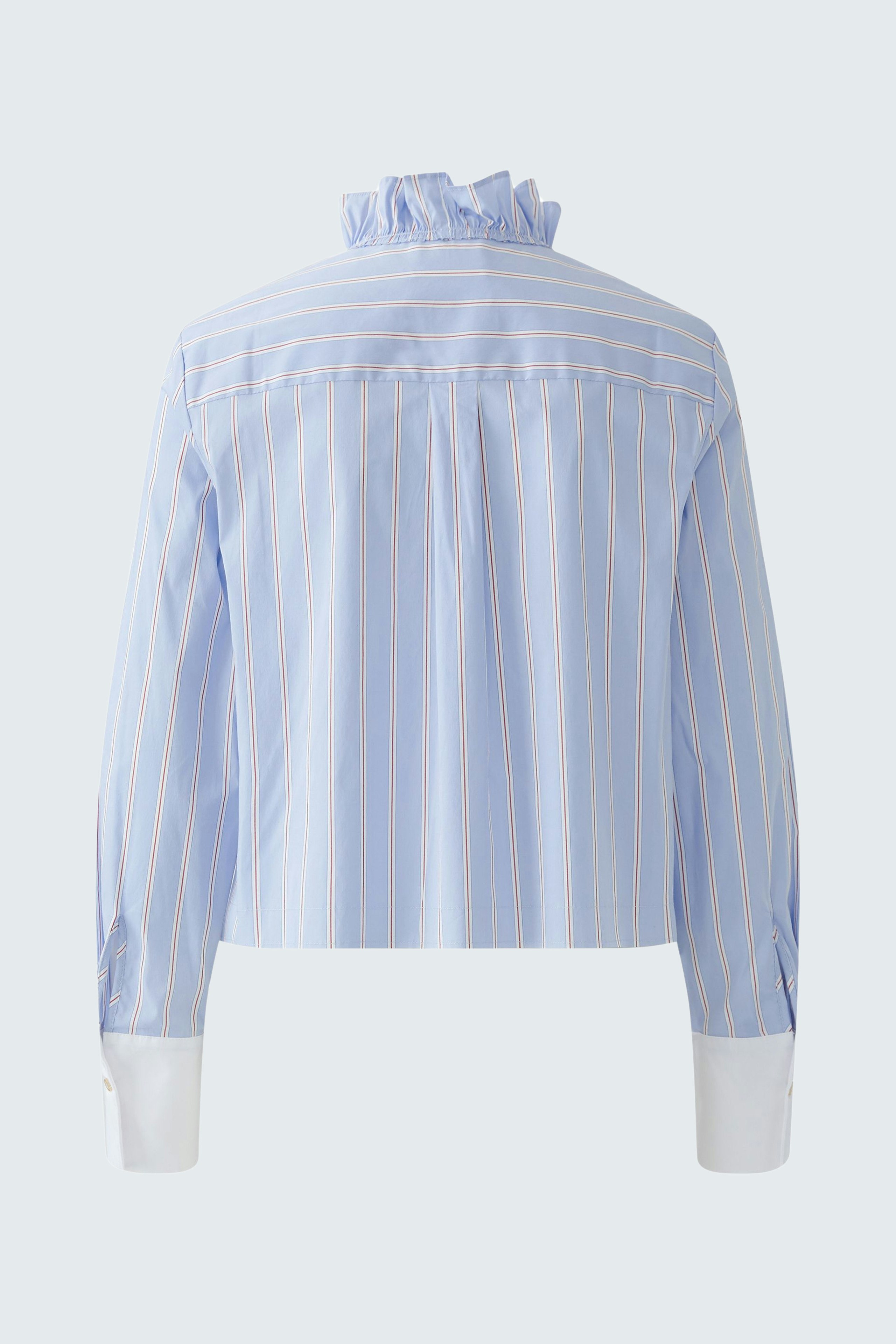 Casual women's blouse: A woman in a light blue striped blouse with a ruffled collar and cuffs.