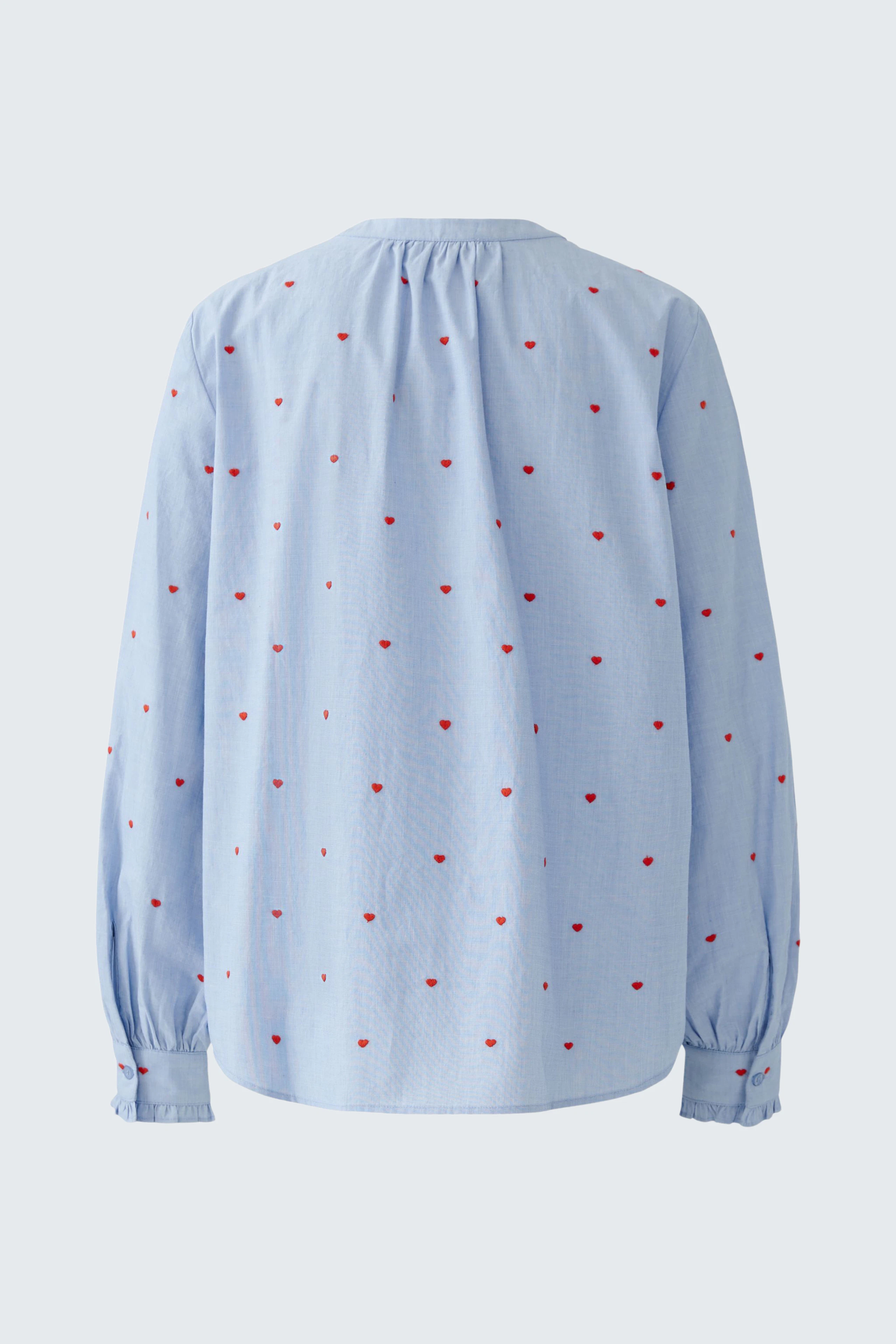 Lässige Damen-Bluse: Rückansicht einer blauen Bluse mit roten Punkten und lockeren Ärmeln.