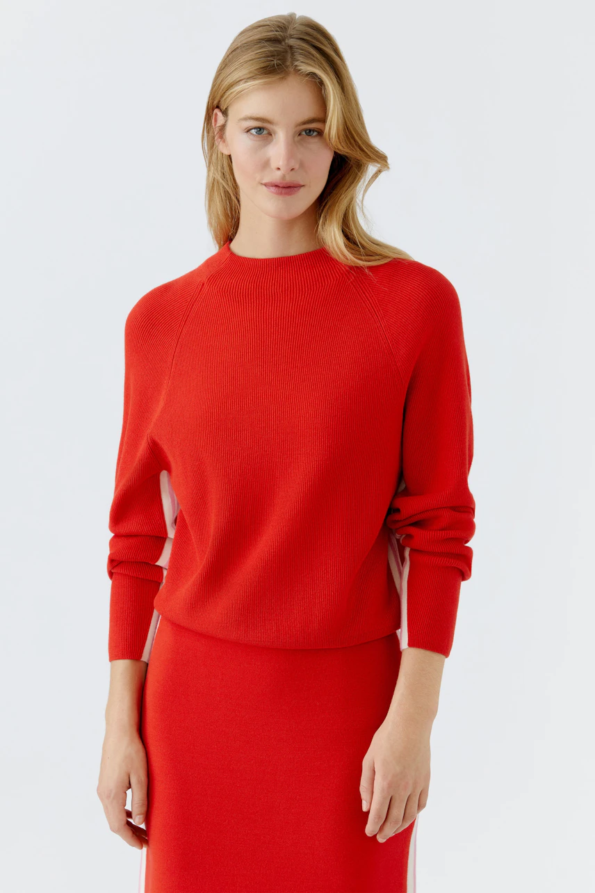 Modern women's pullover: A woman in a vibrant red pullover with a relaxed fit and stylish design.