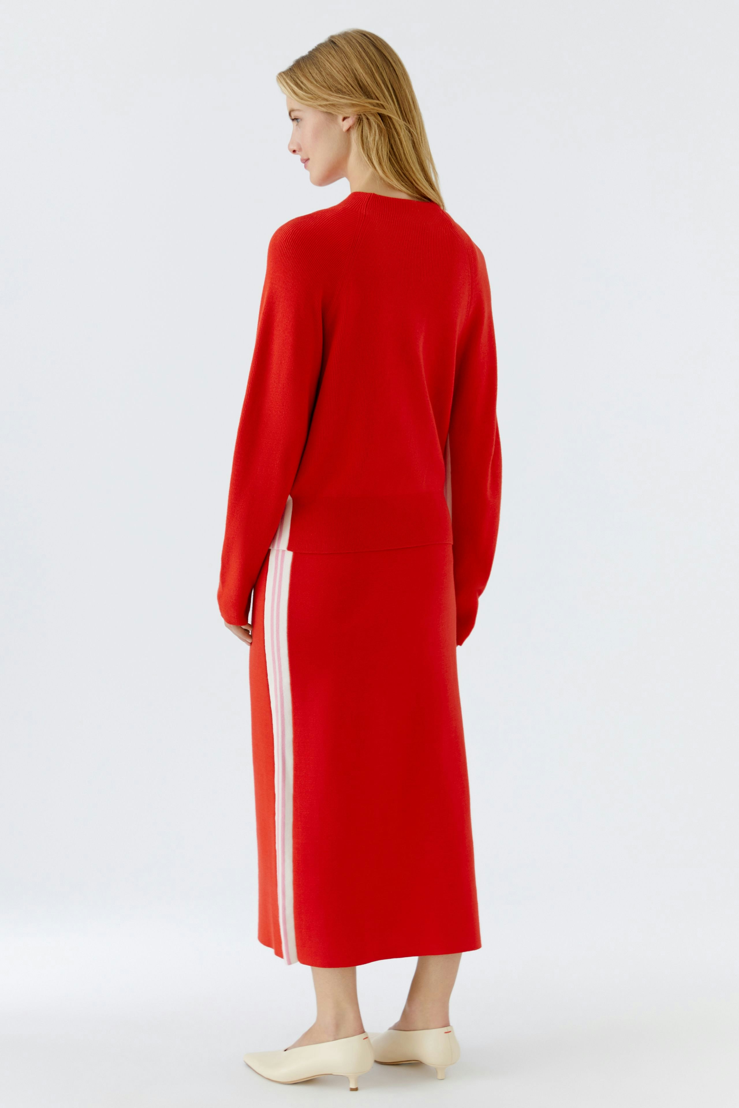 Casual women's pullover: A woman in a red pullover with a relaxed fit, showcasing a stylish back view.