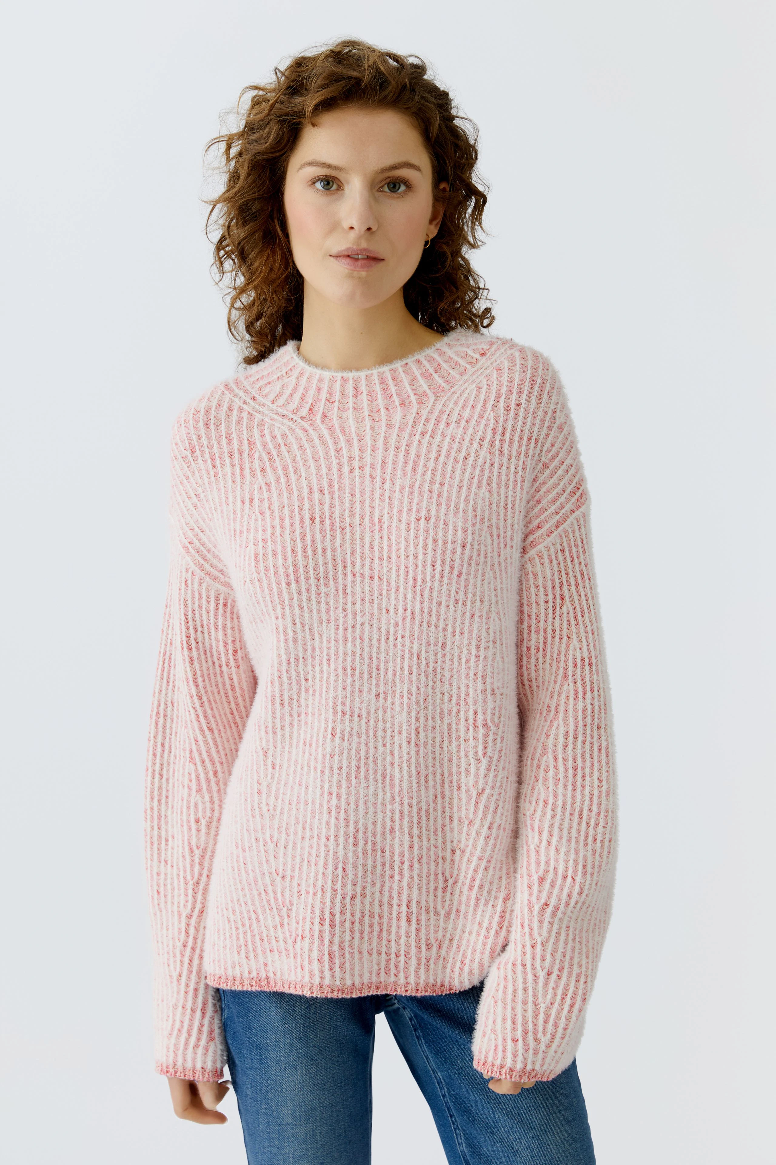 Casual women's pullover: Young woman in a pink striped pullover with relaxed fit.