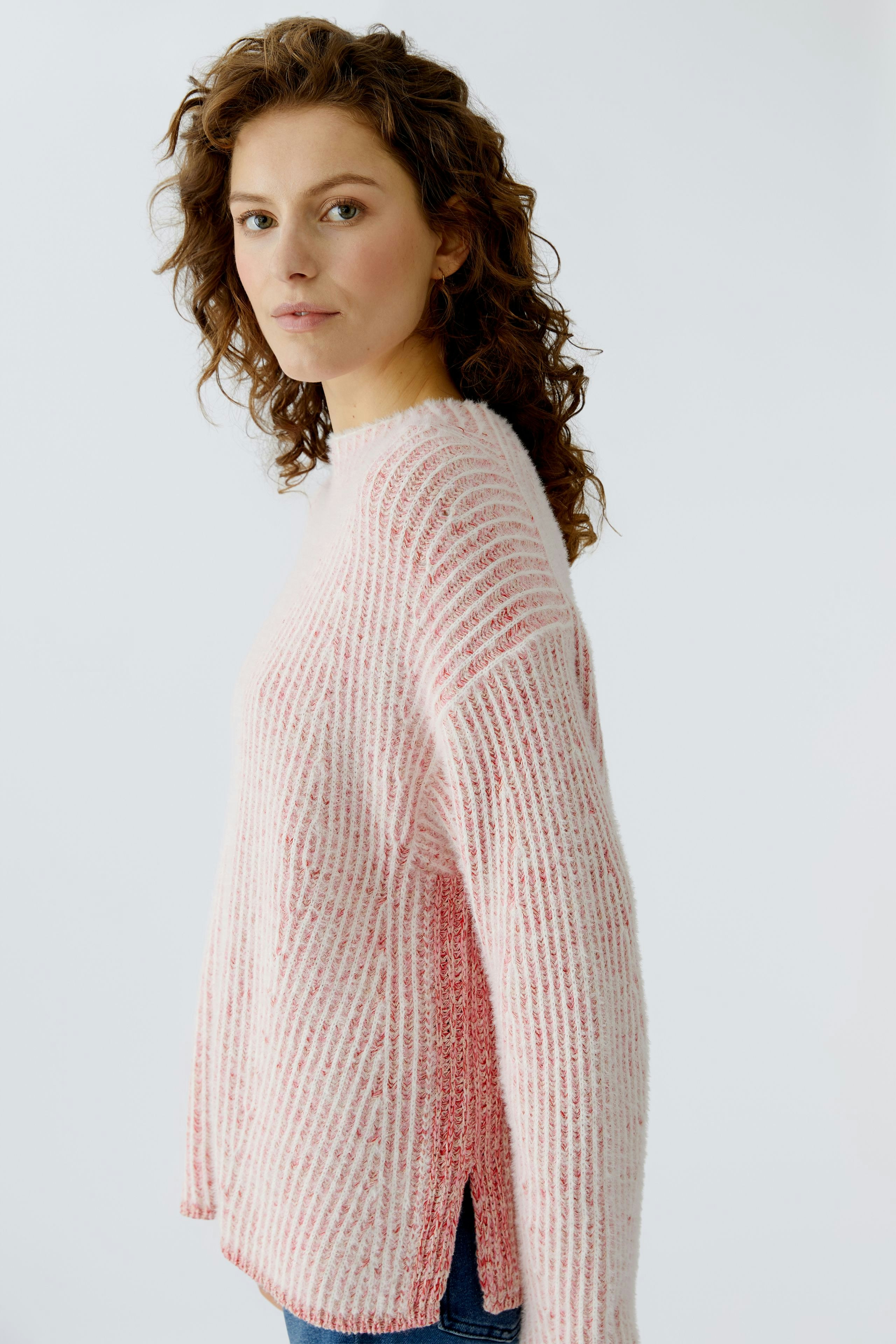 Casual women's pullover: Young woman in a pink striped pullover with a relaxed fit.