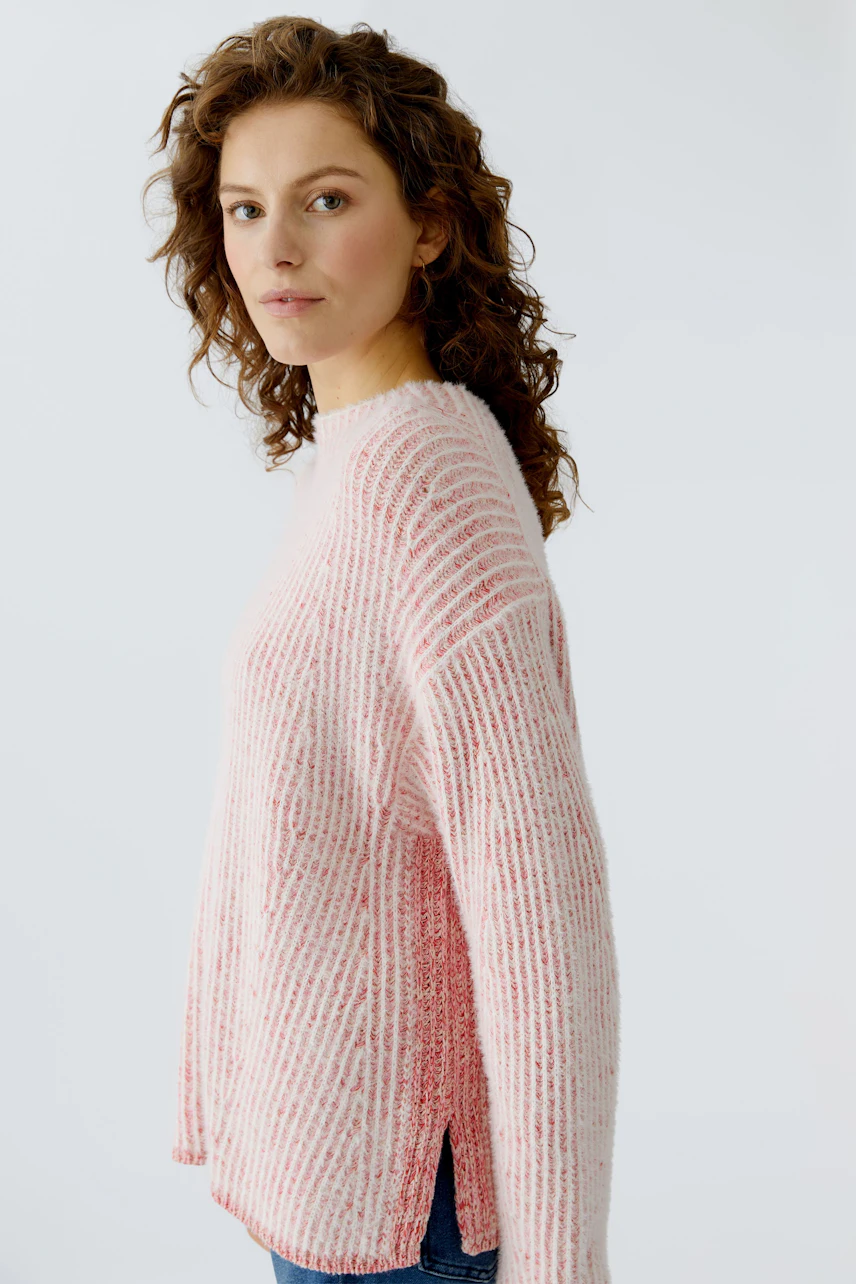 Casual women's pullover: Young woman in a pink striped pullover with a relaxed fit.