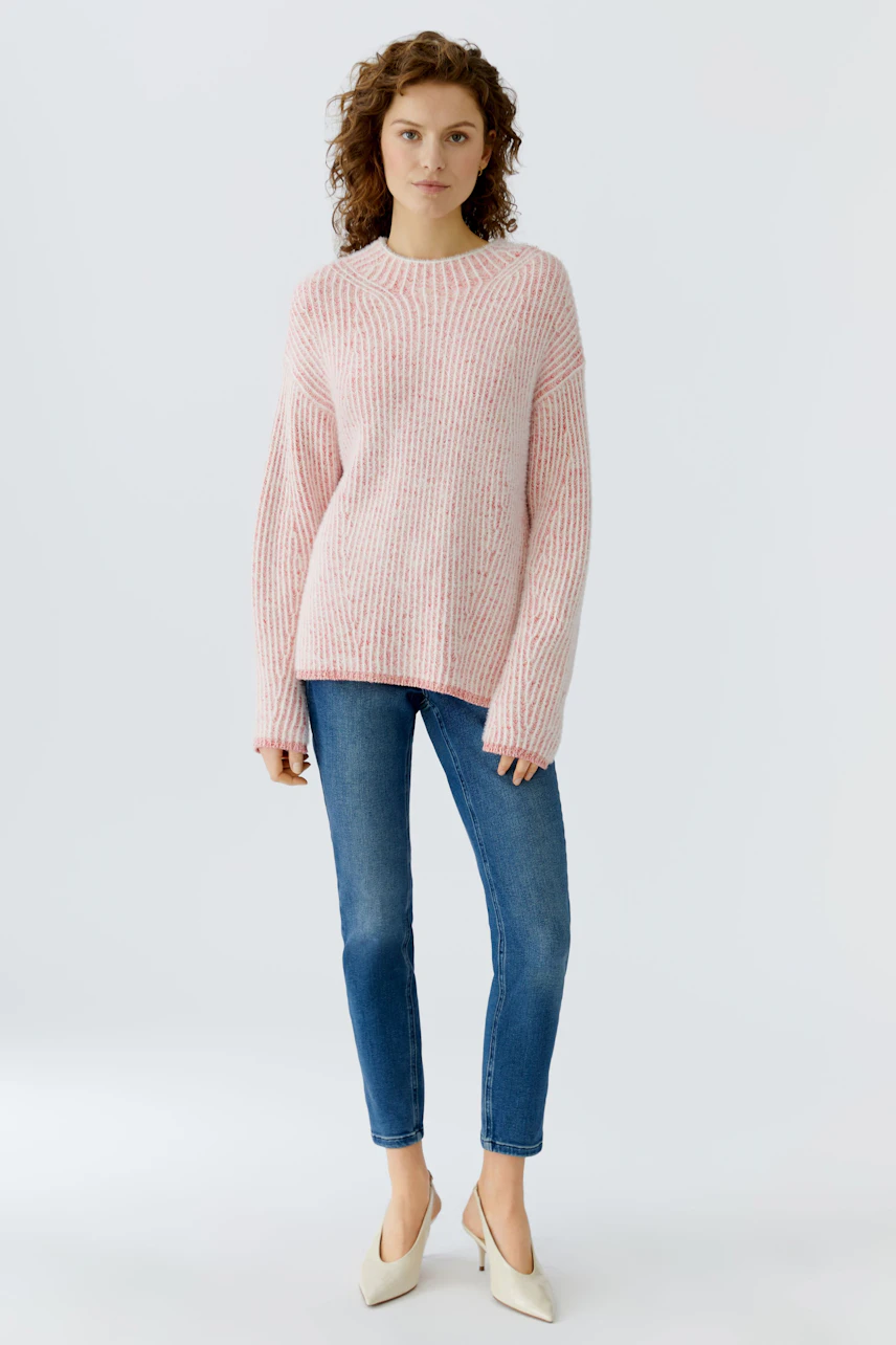 Casual women's pullover: Young woman in a pink knitted pullover with a relaxed fit.