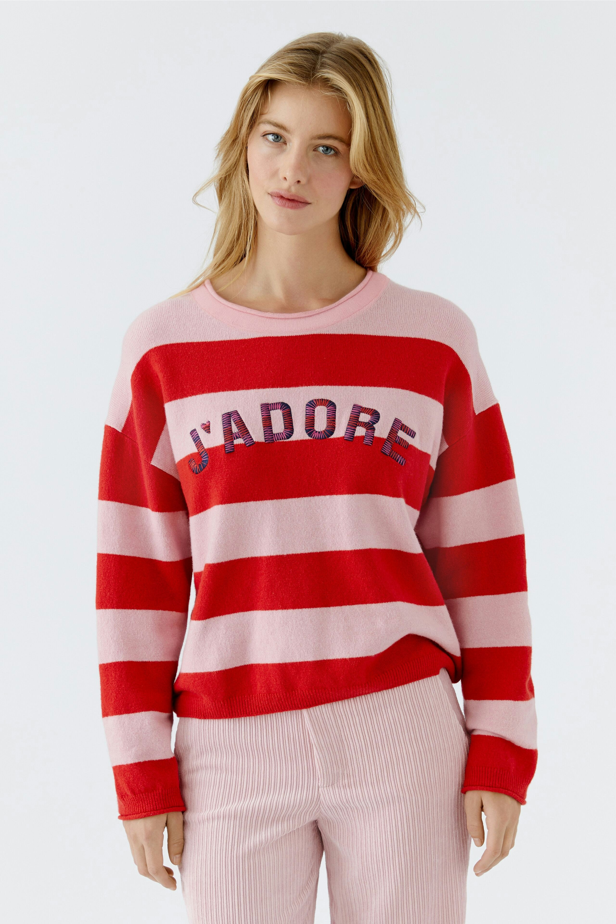 Damen-Pullover: Frau in gestreiftem Pullover mit Schriftzug, lässig und modern.