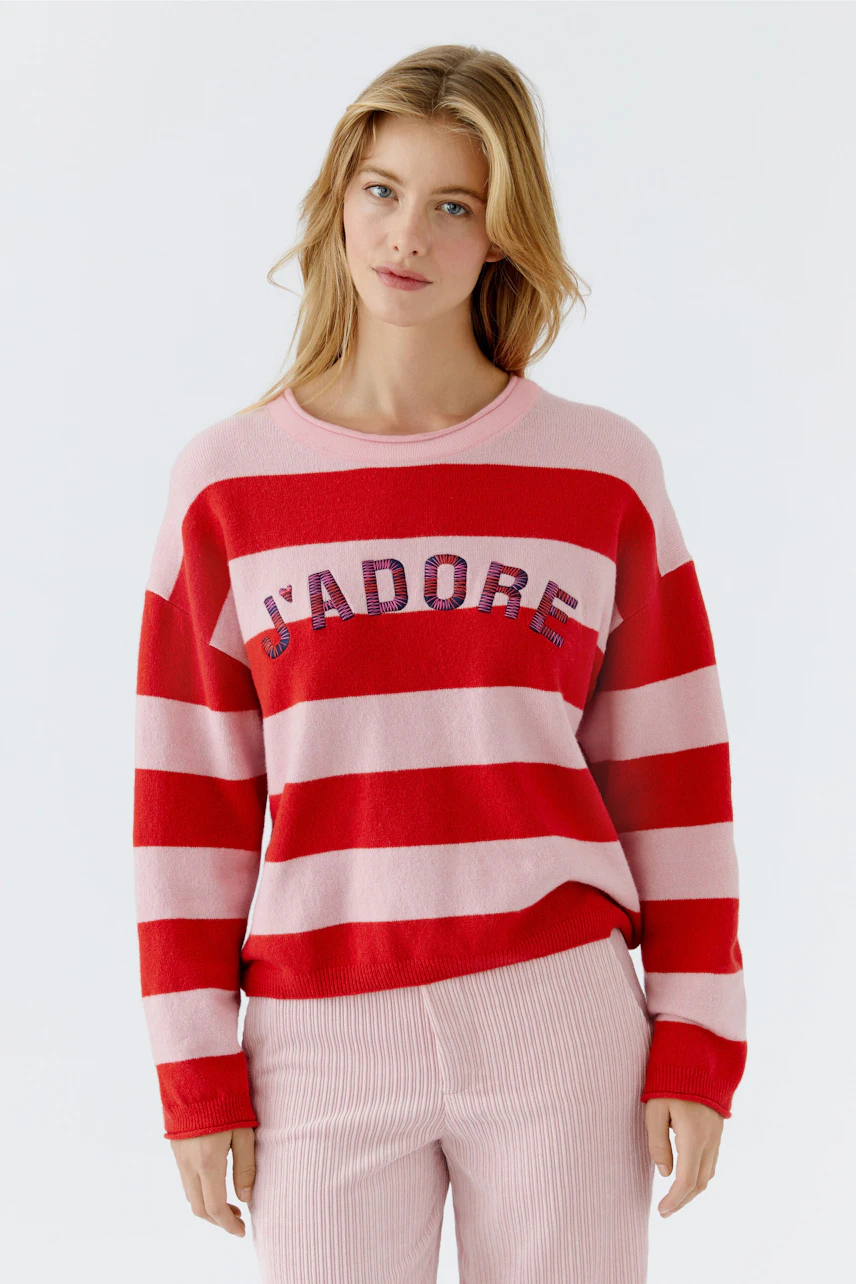 Casual women's pullover: Young woman in a red and pink striped pullover with 'J'ADORE' lettering.