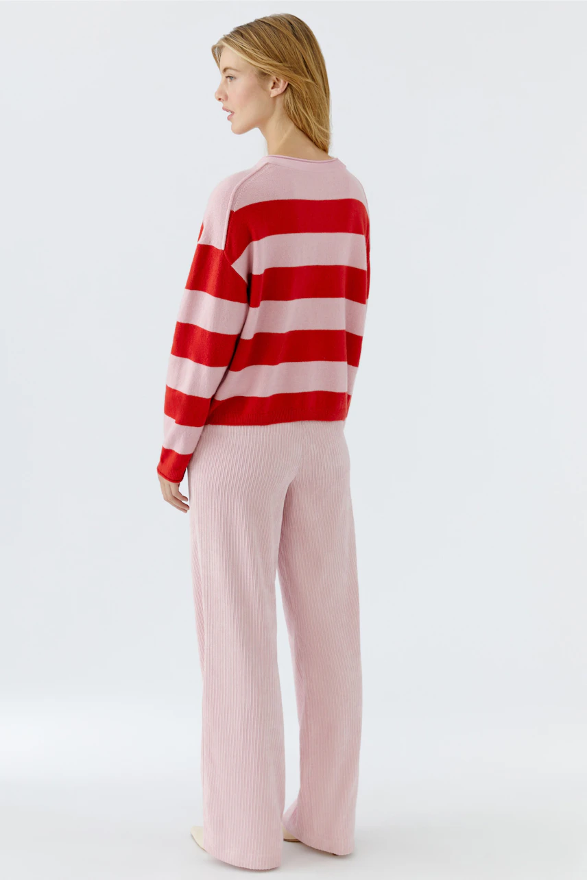 Casual women's pullover: Young woman in a pink and red striped pullover with relaxed fit.