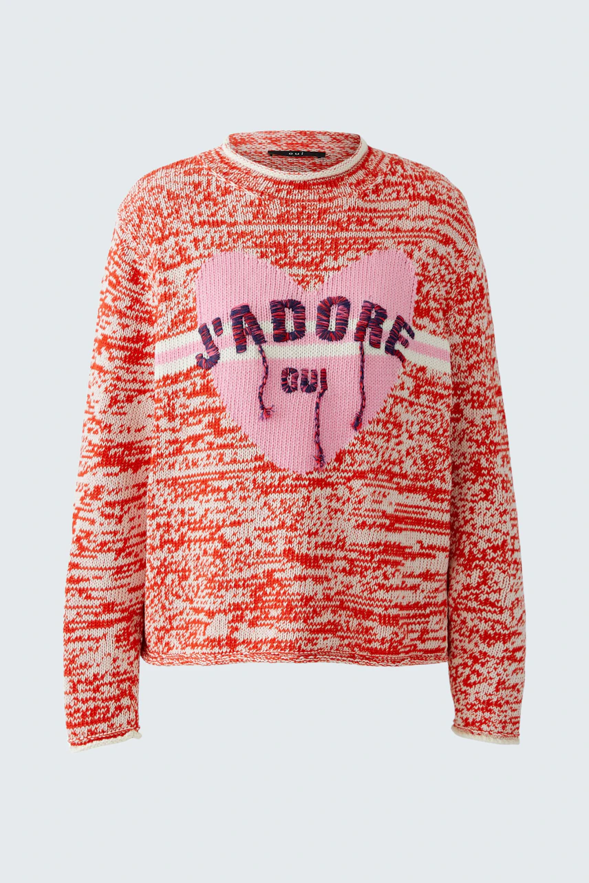 Casual women's pullover: A woman in a red and pink knit pullover with a heart design and bold lettering.