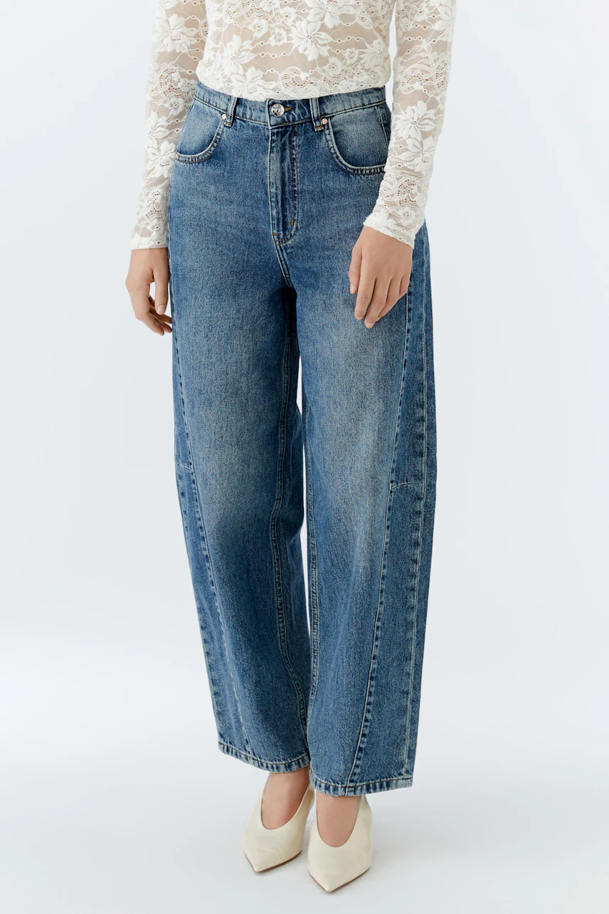 Casual women's barrel jeans: A woman in relaxed-fit blue jeans with a high waist and wide legs.