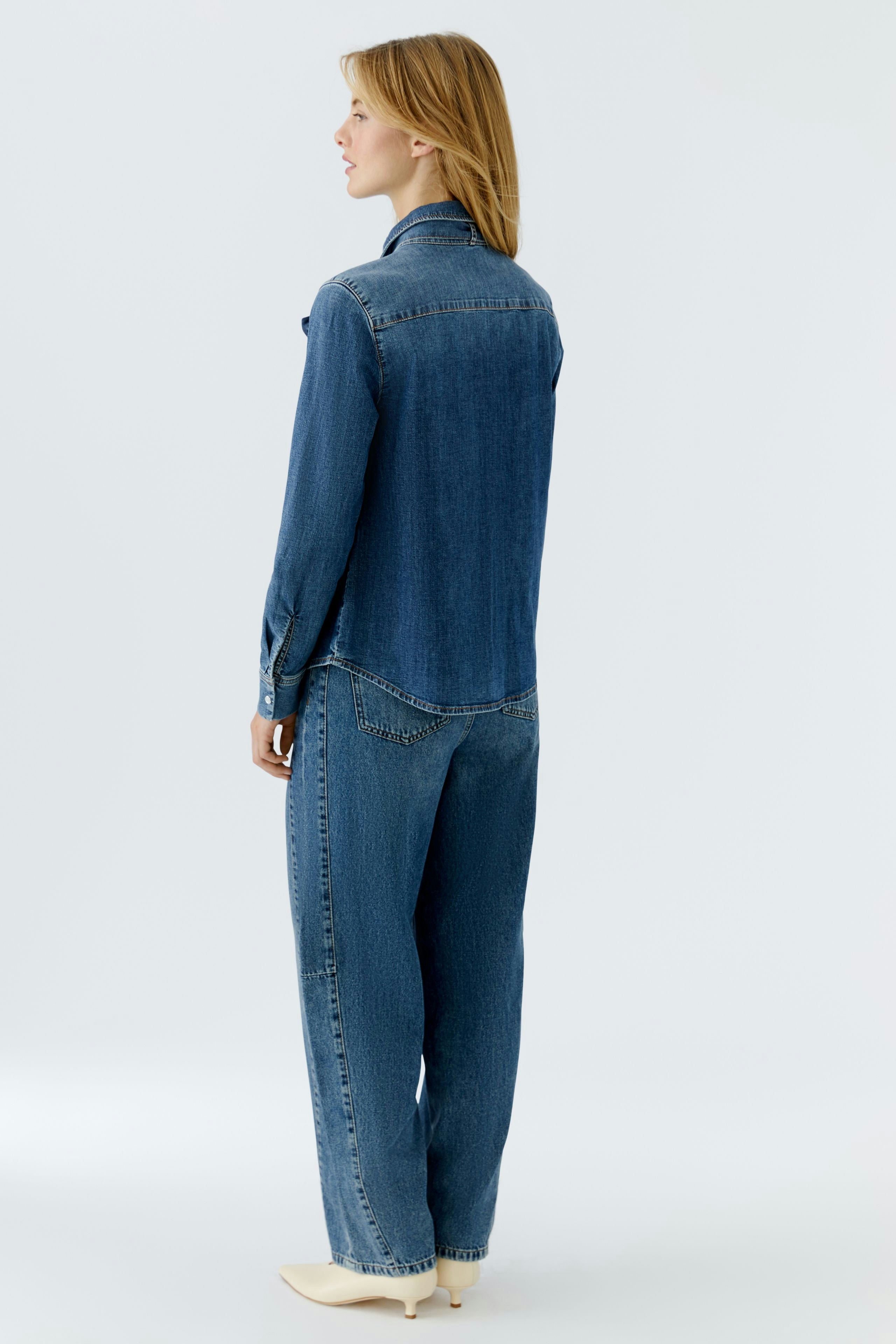 Casual women's jeans barrel: A woman in a relaxed fit denim shirt and loose jeans, showcasing a laid-back style.