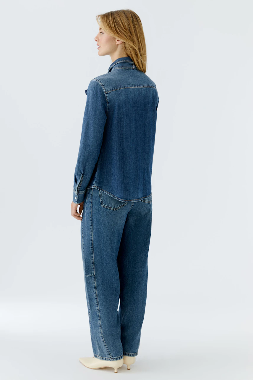 Casual women's jeans barrel: A woman in a relaxed fit denim shirt and loose jeans, showcasing a laid-back style.