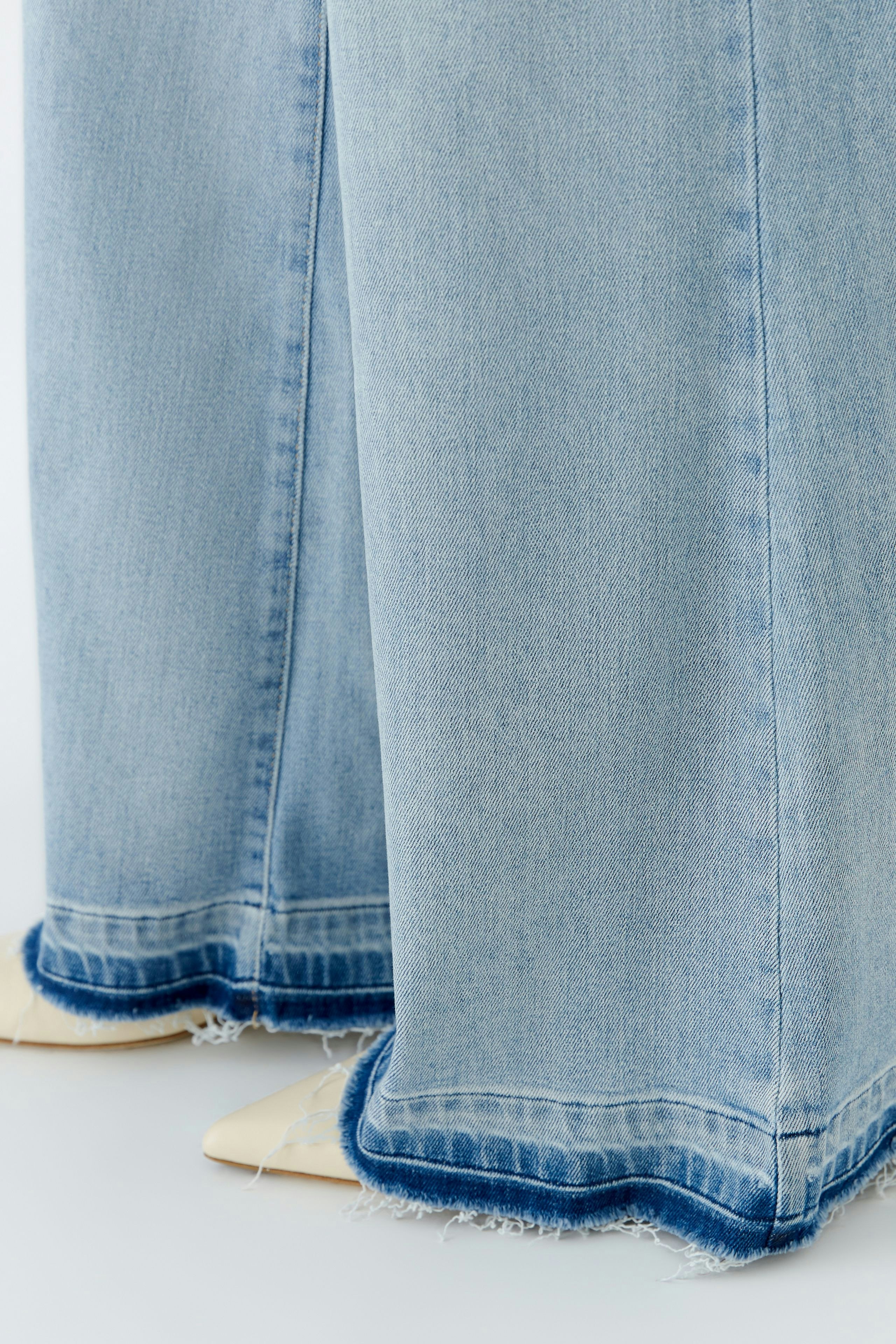 Casual women's flared jeans: Light blue denim with a frayed hem, perfect for a relaxed look.