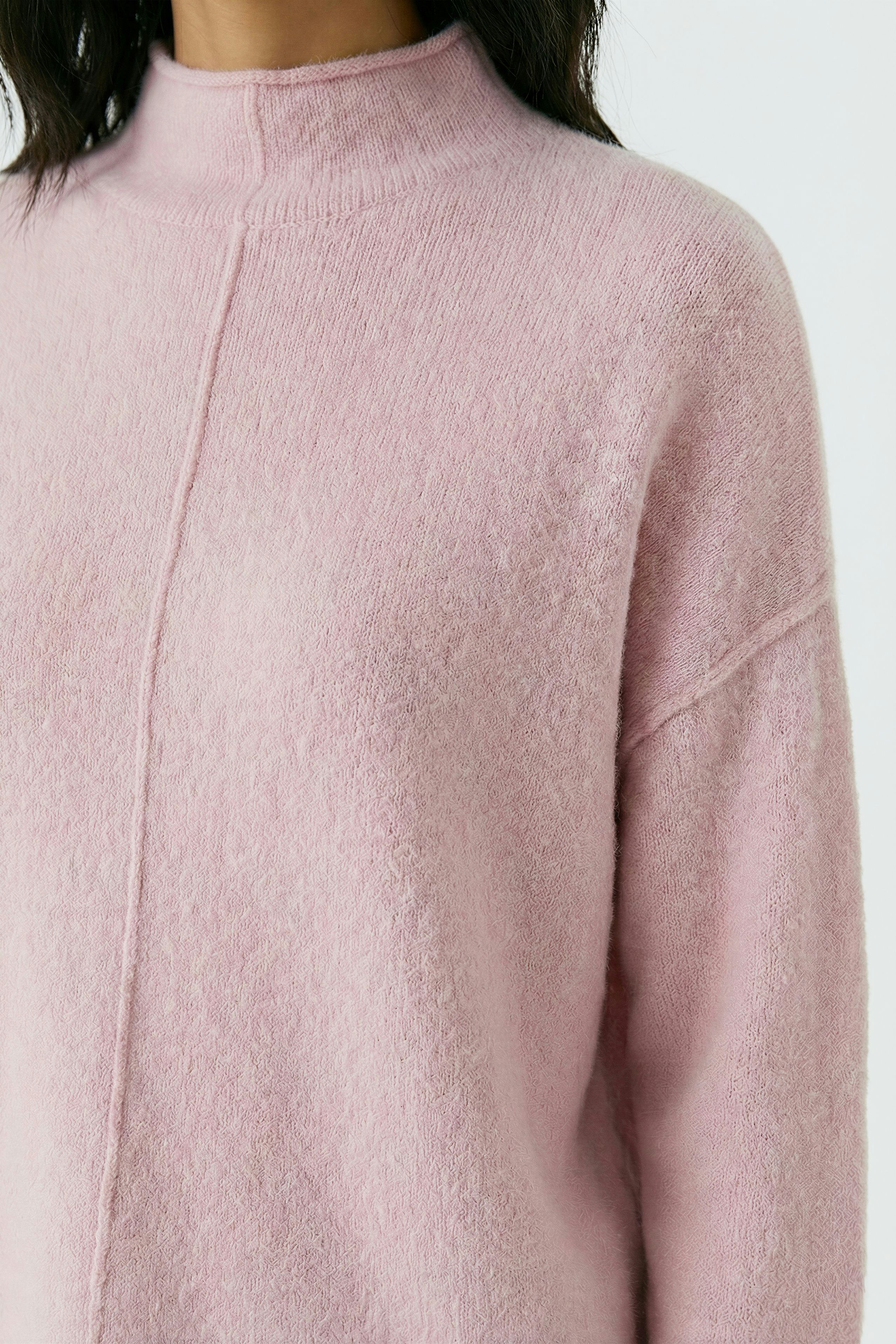 Damen-Pullover in zartem Rosa: Frau trägt einen weichen, lässigen Pullover mit Stehkragen.