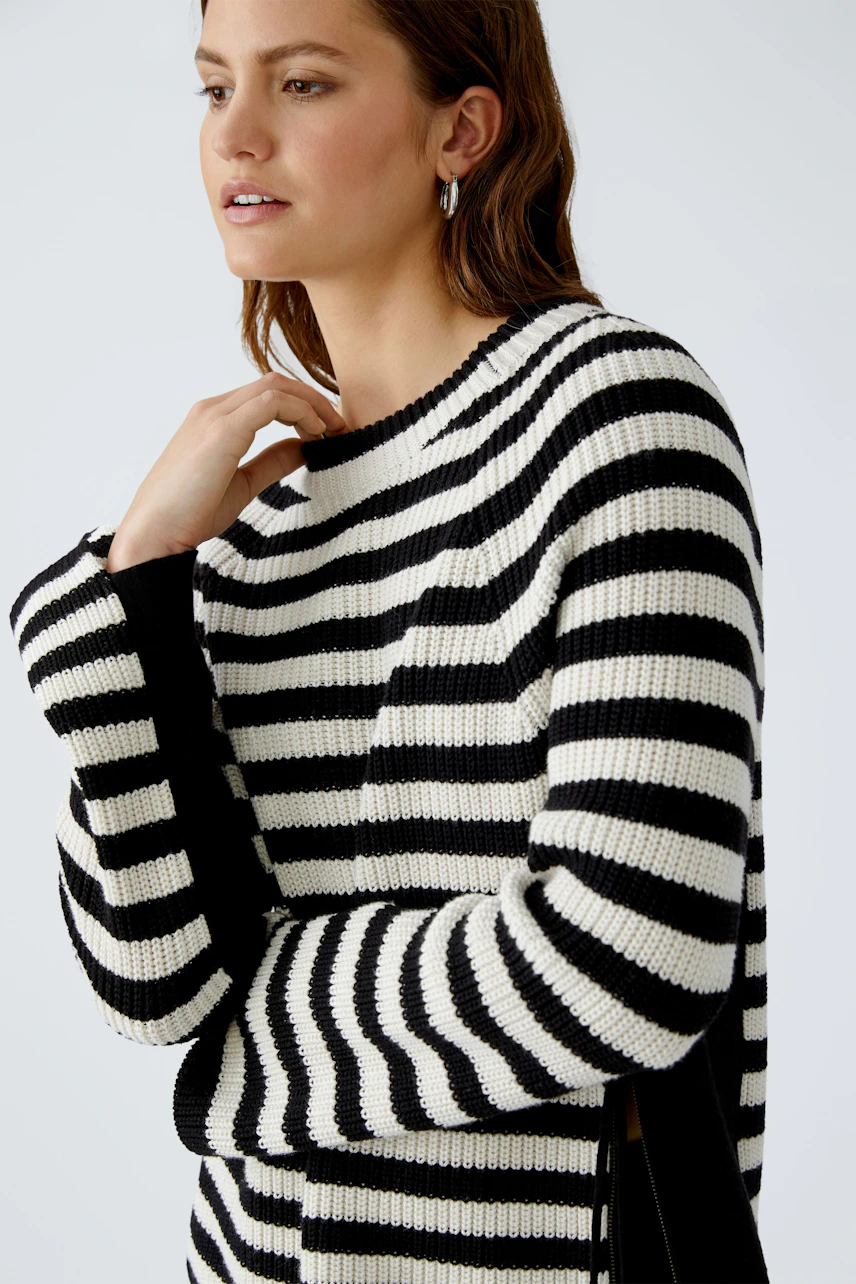 Modern women's pullover: A woman in a striped pullover with side slits, exuding effortless style.