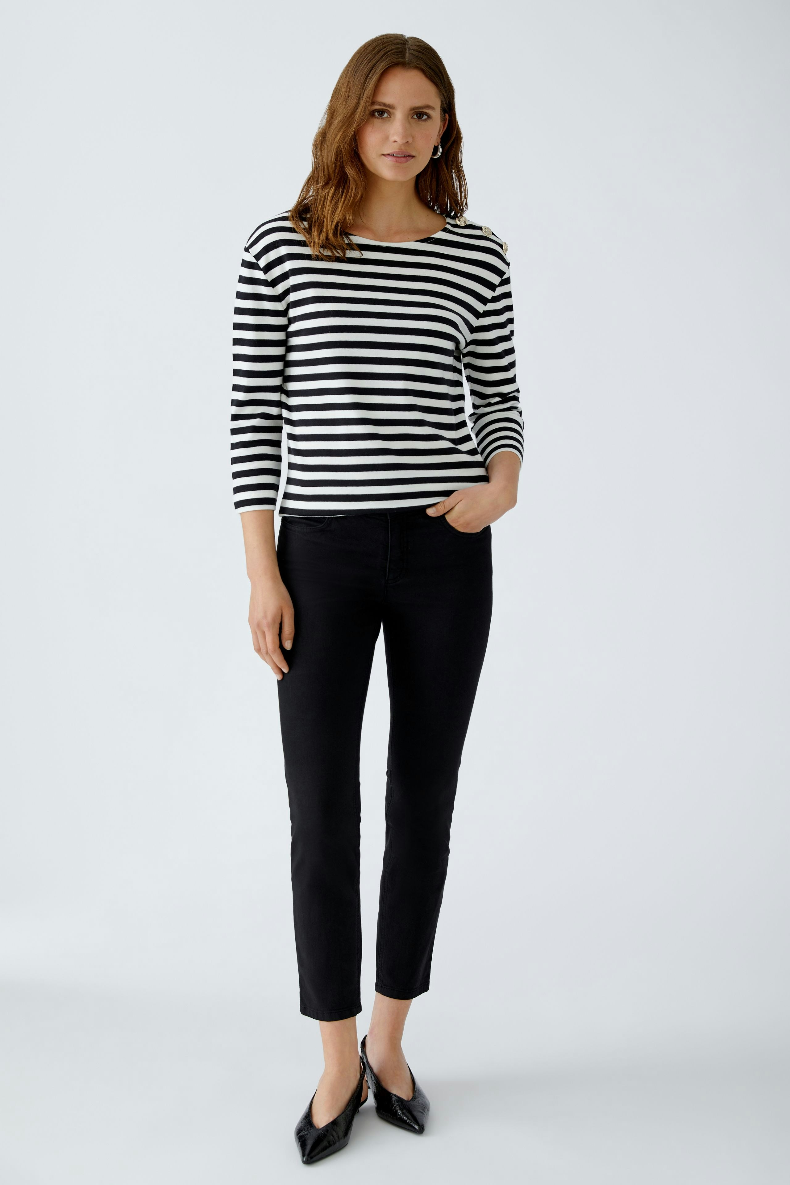 Stylish women's long-sleeve shirt: A woman in a striped top paired with flared jeans.