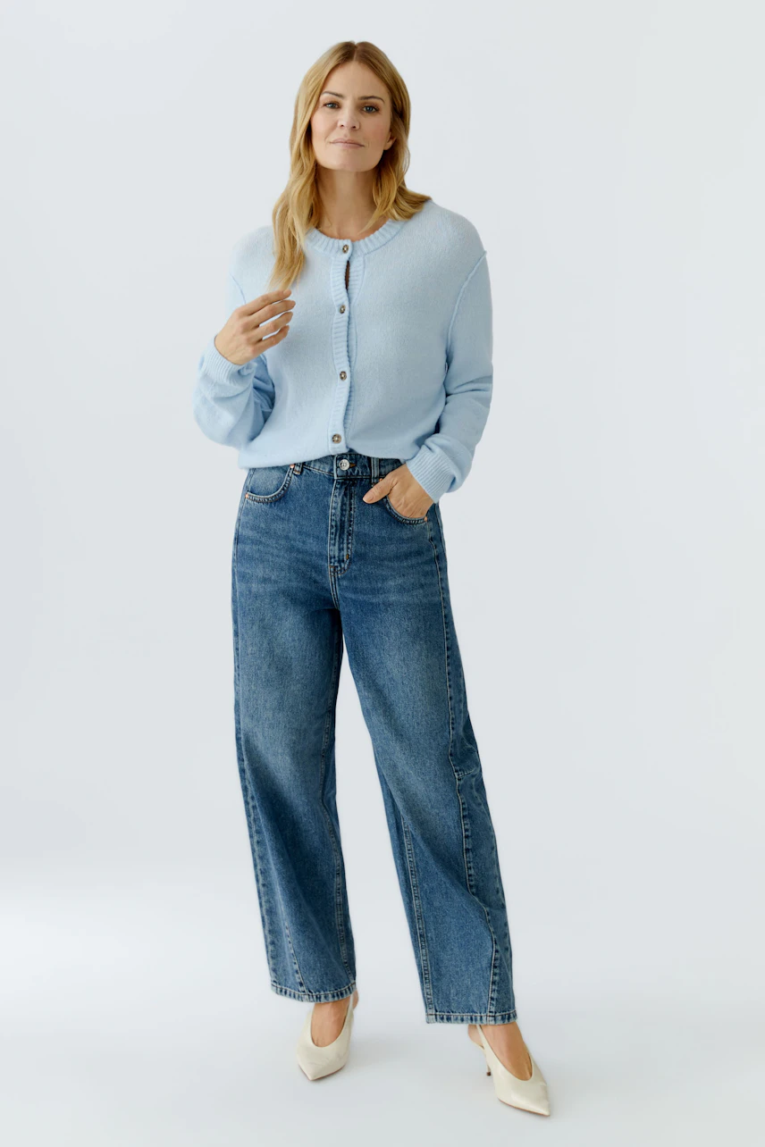 Casual women's cardigan: A woman in a light blue cardigan with buttons, paired with wide-leg jeans.