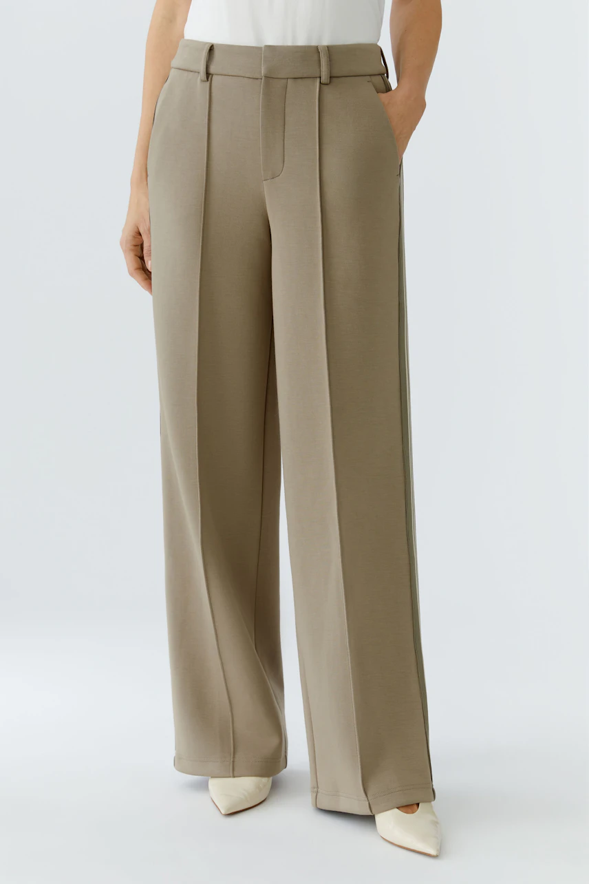 Comfortable women's trousers in a light beige tone, featuring a relaxed fit and side pockets.