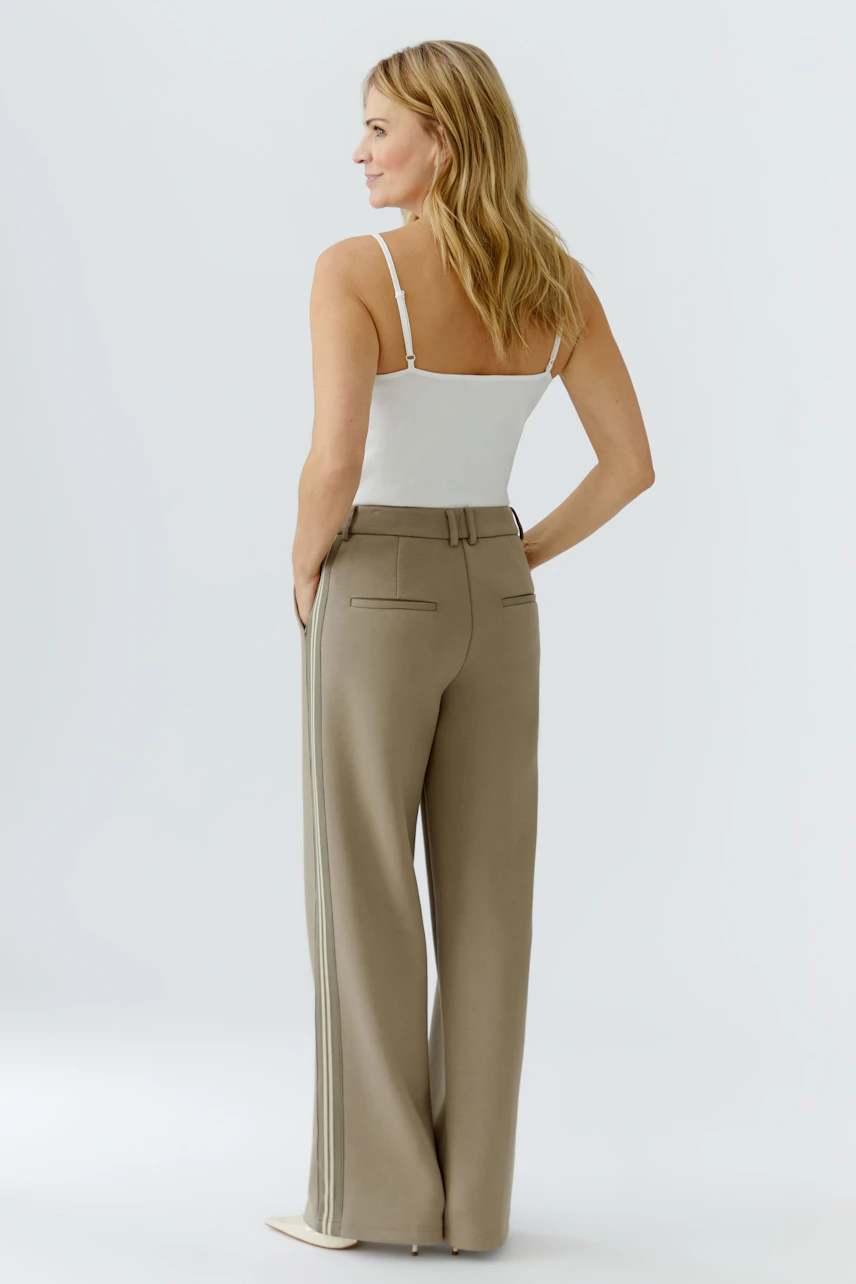 Casual women's trousers: A woman in beige wide-leg trousers with a simple white top, showcasing a relaxed fit.