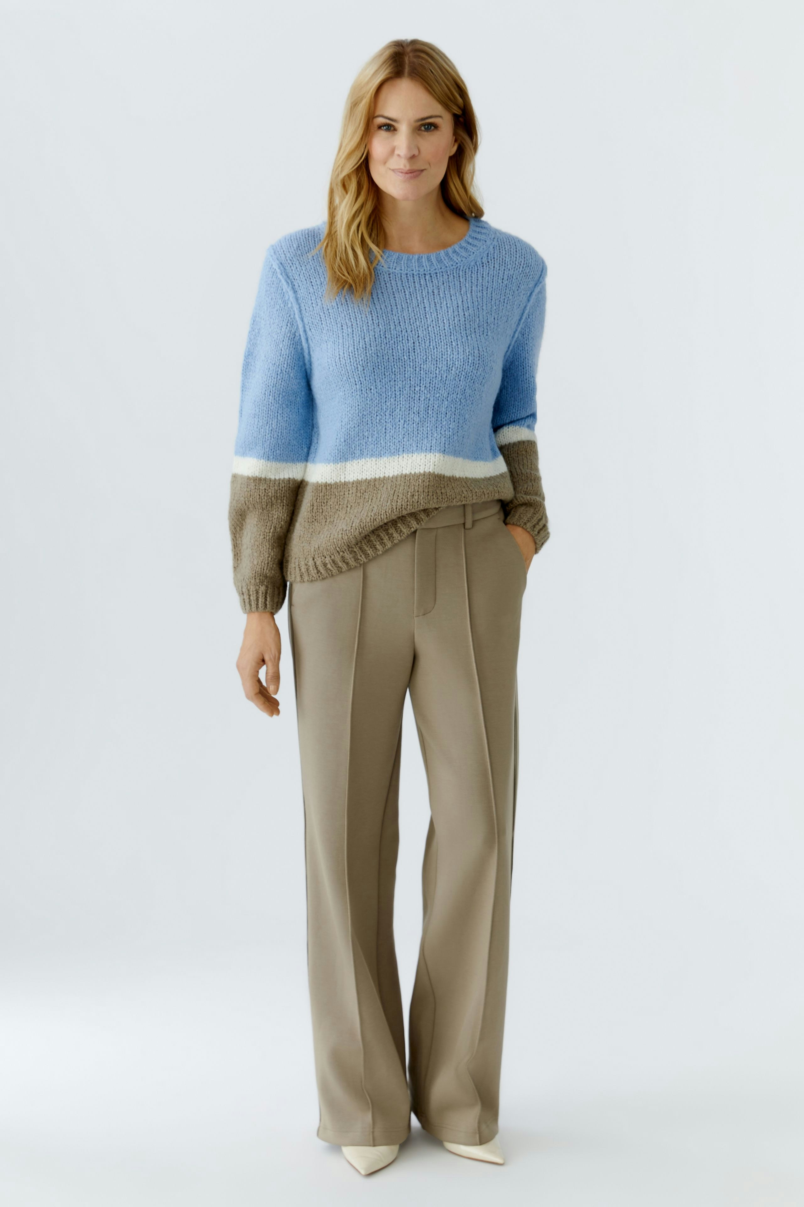 Damen-Pullover in Blau und Beige: Frau trägt einen lässigen, farbigen Strickpullover.