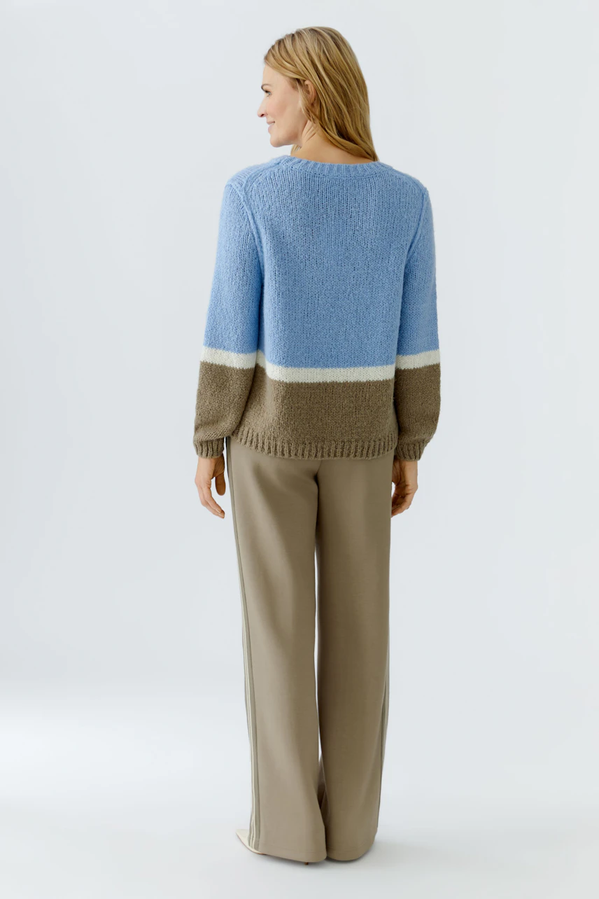 Casual women's pullover: A woman in a blue and brown striped pullover with relaxed fit.
