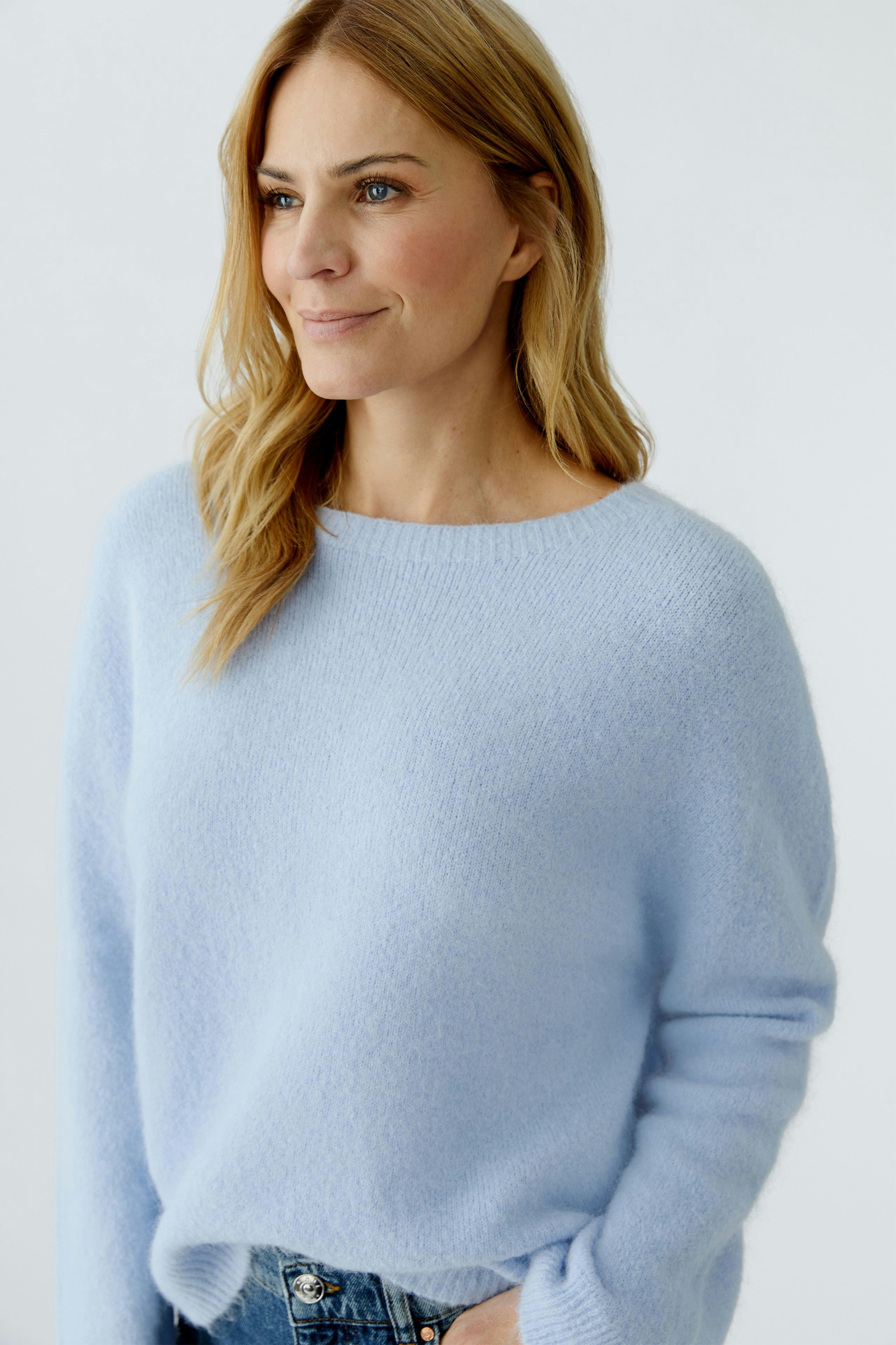 Casual women's pullover: A woman in a light blue, soft pullover with a relaxed fit.