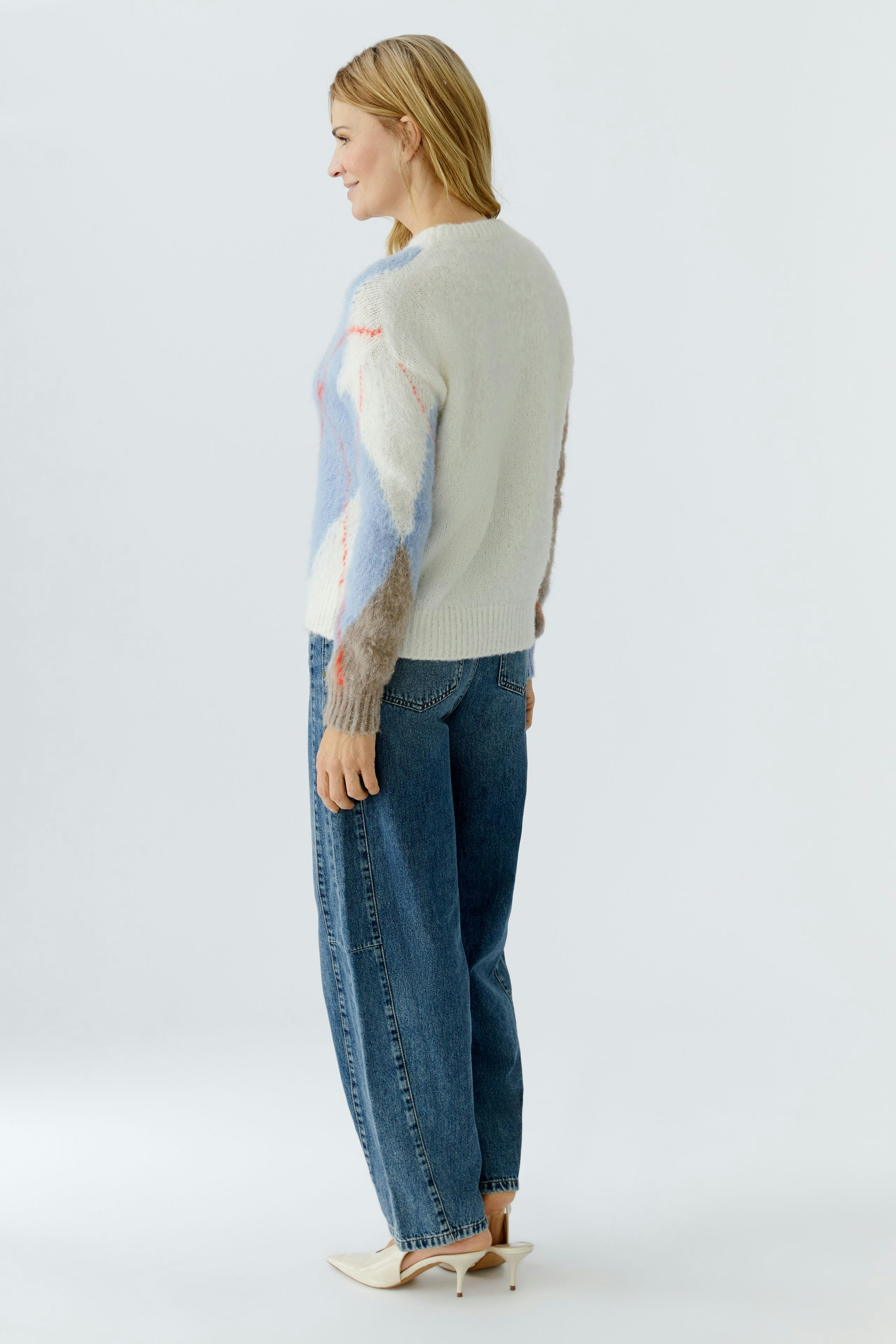 Casual women's pullover: A woman in a cozy pullover with colorful patterns and relaxed jeans.