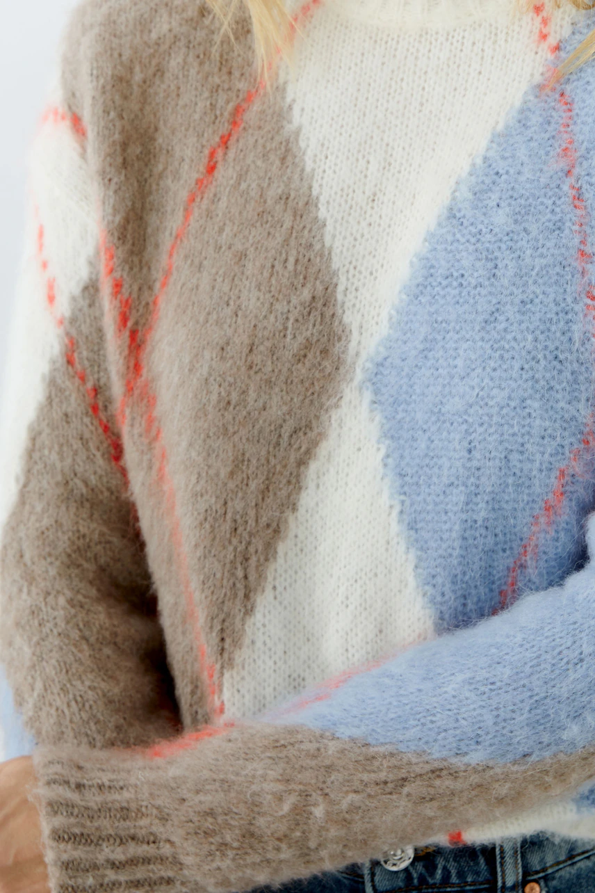 Cozy women's pullover: A woman in a soft, colorful knit pullover with a diamond pattern.